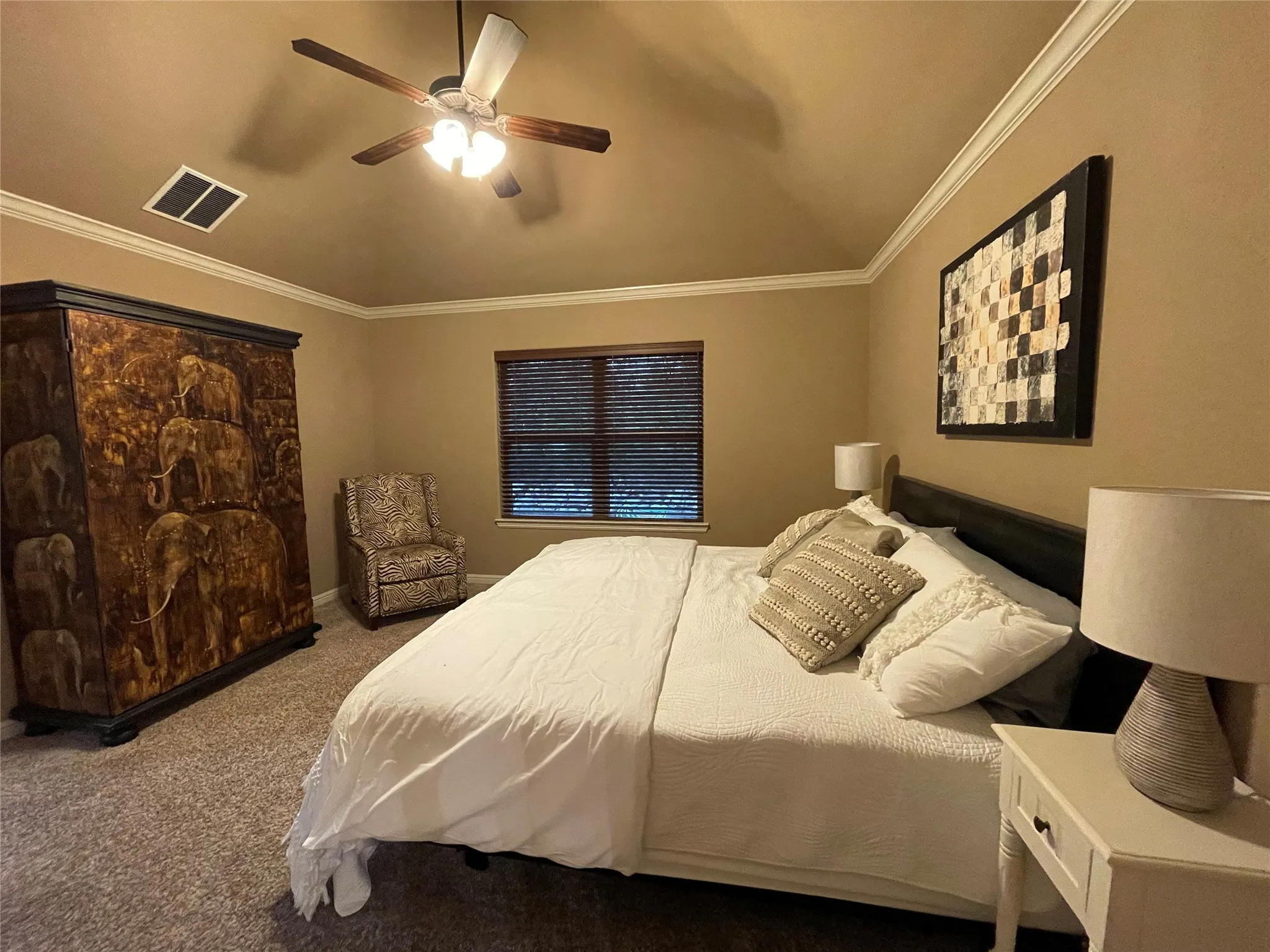 Vaulted ceiling with crown molding, ceiling fan with integrated lighting, window with horizontal blinds, and carpeting