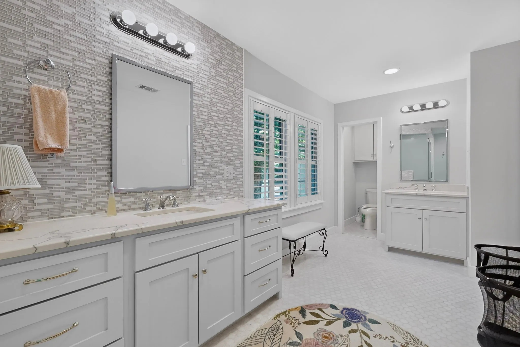 Dual vanity with white cabinetry, integrated sinks, and polished chrome fixtures