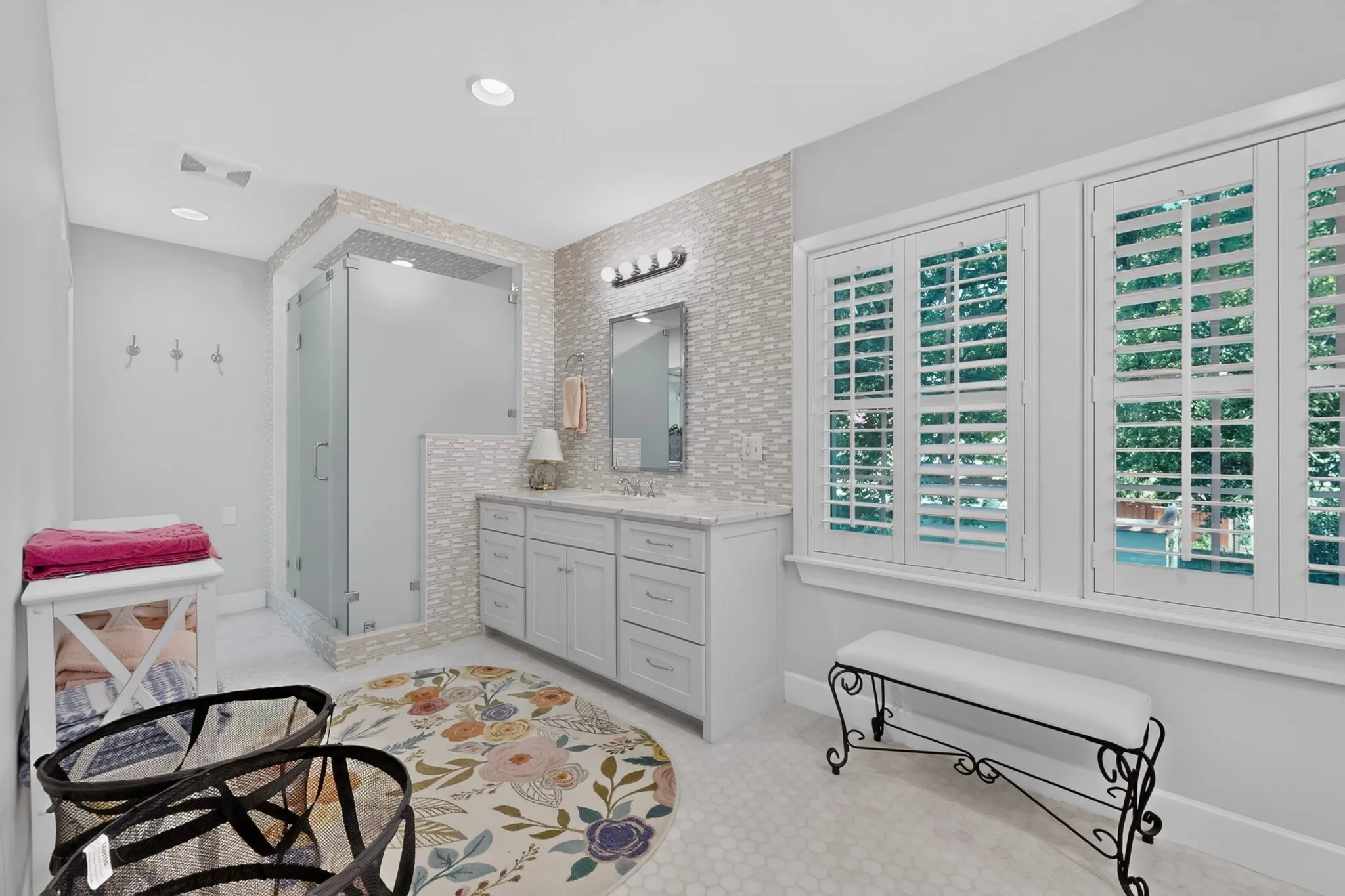 Vanity with a light-colored countertop, framed mirror, and three light fixtures