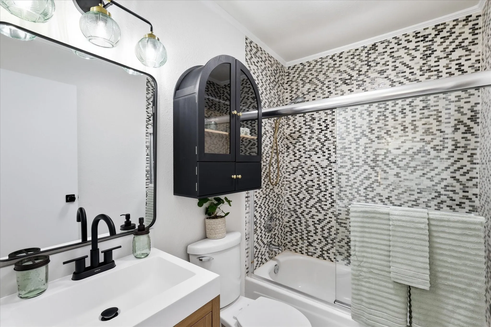 White vanity with integrated sink, matte black faucet, and wood-finish cabinetry