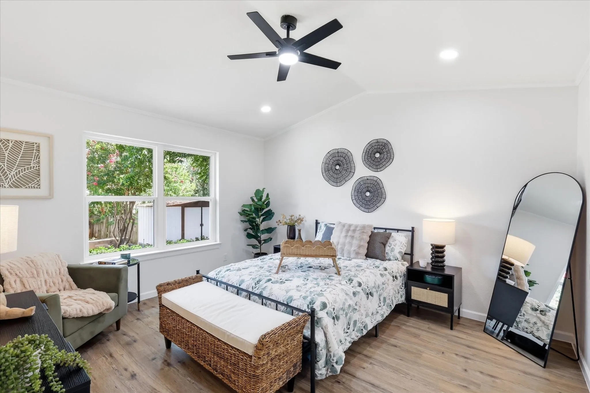 Vaulted ceiling with a contemporary ceiling fan, recessed lighting, expansive window, wood-finish flooring, and white painted walls