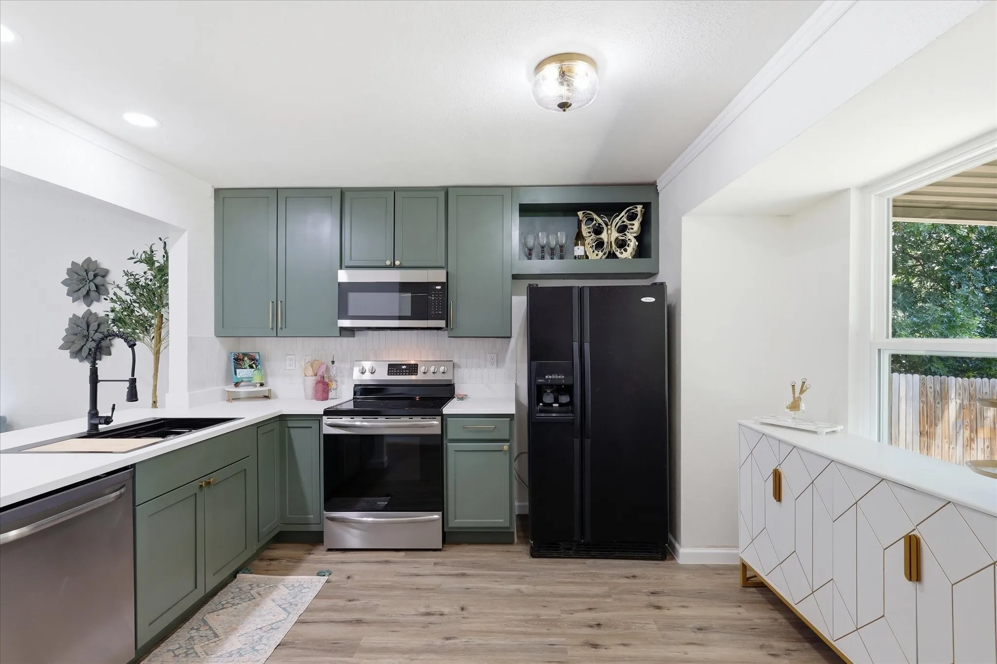 Kitchen featuring wood-finish flooring, recessed lighting, white countertops, green cabinetry, and stainless steel appliances