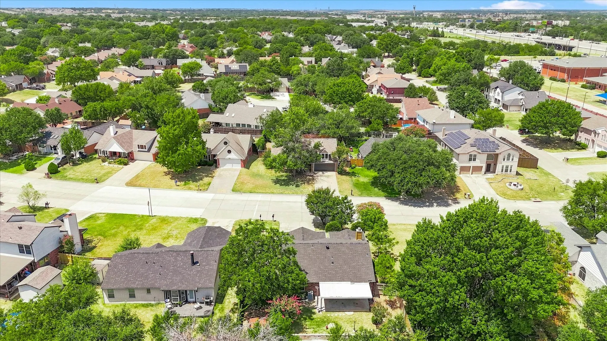 Residential area with mature tree canopy, varied architectural styles, and established streetscapes