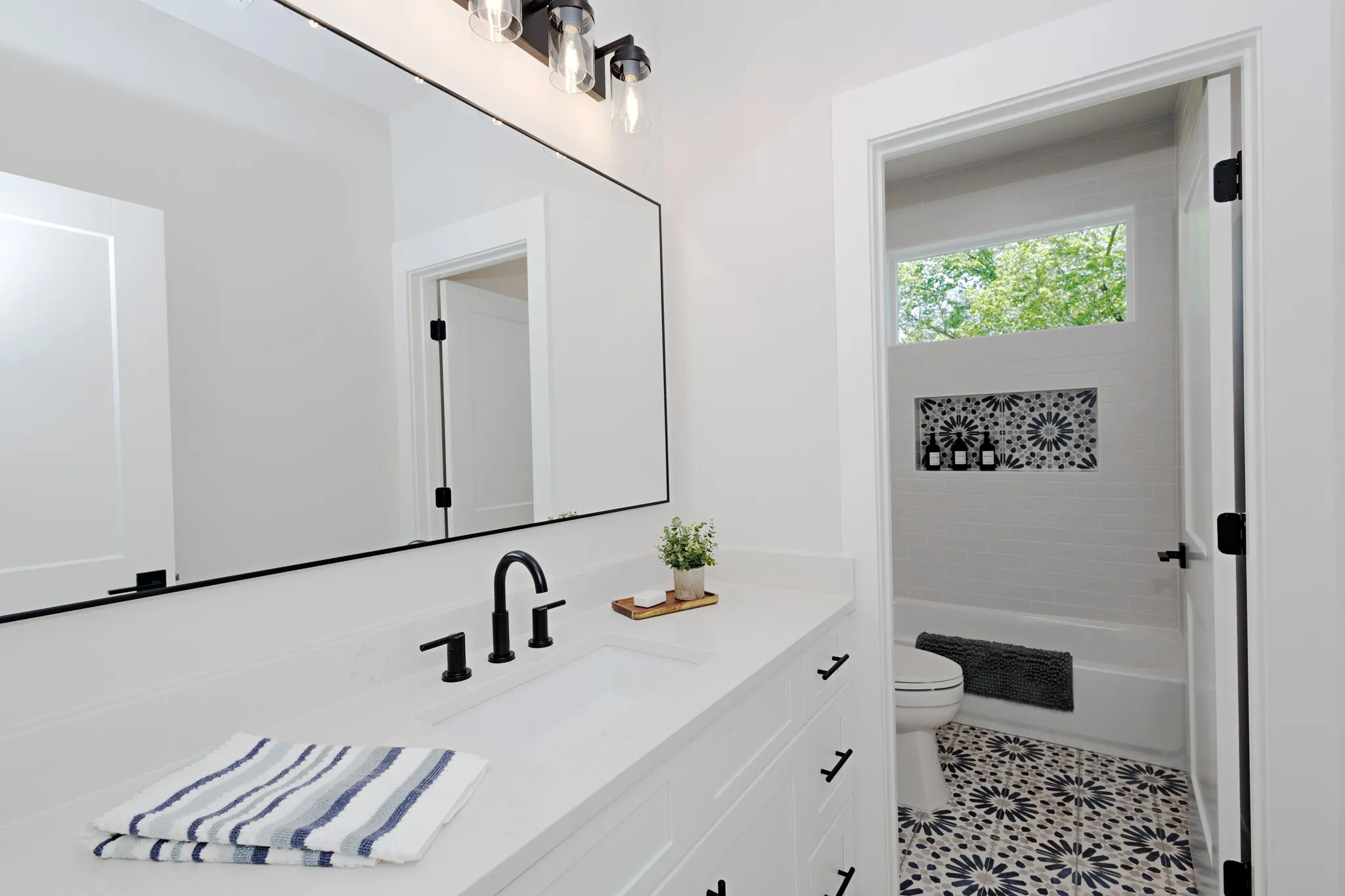 Bright and Modern Guest Bathroom offers designer tile floors and accents.