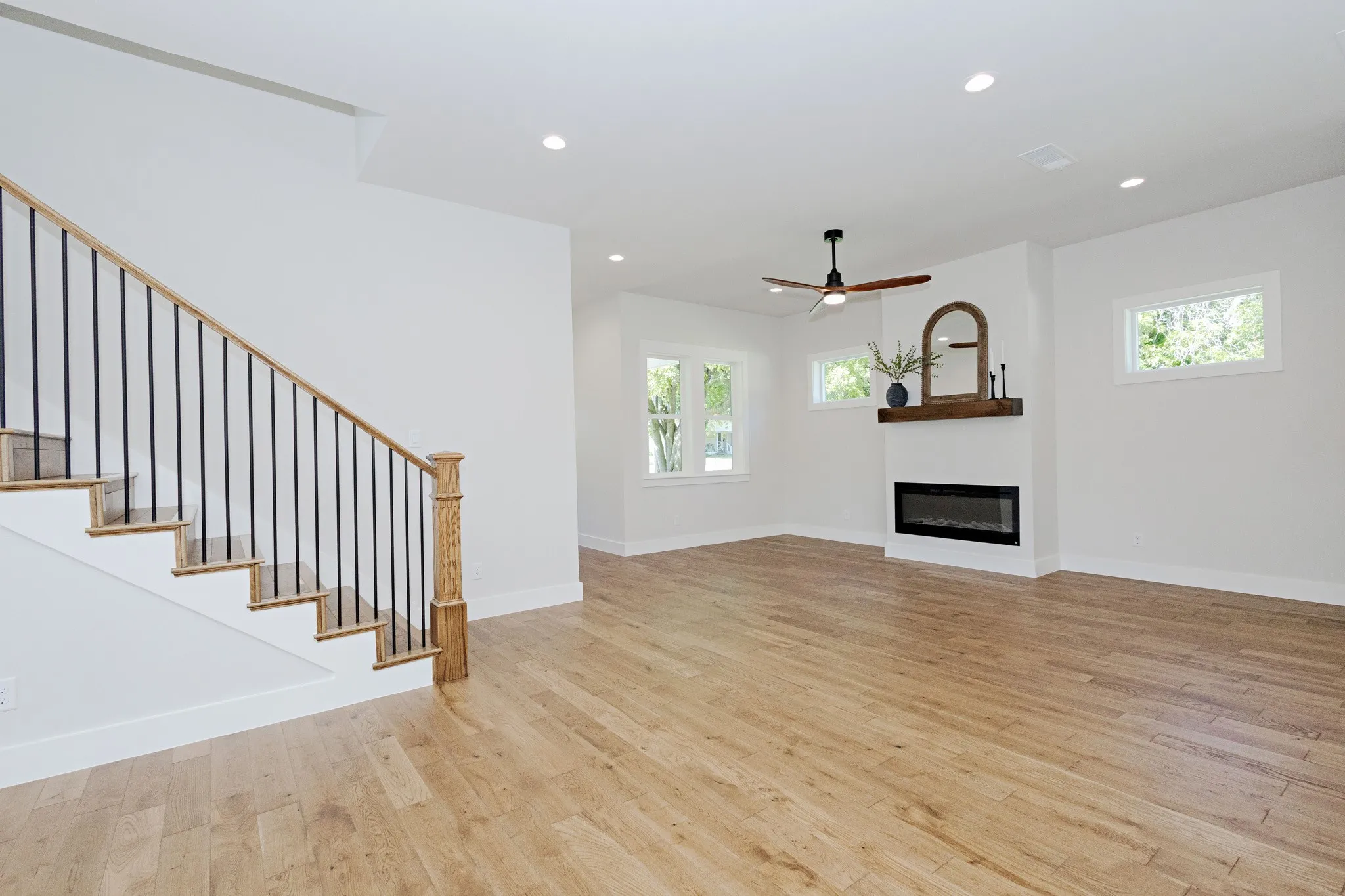 Soft, Neutral French Oak Solid Hardwood Floors and a sleek Electric Heat-Producing Fireplace create a warm, inviting living space.