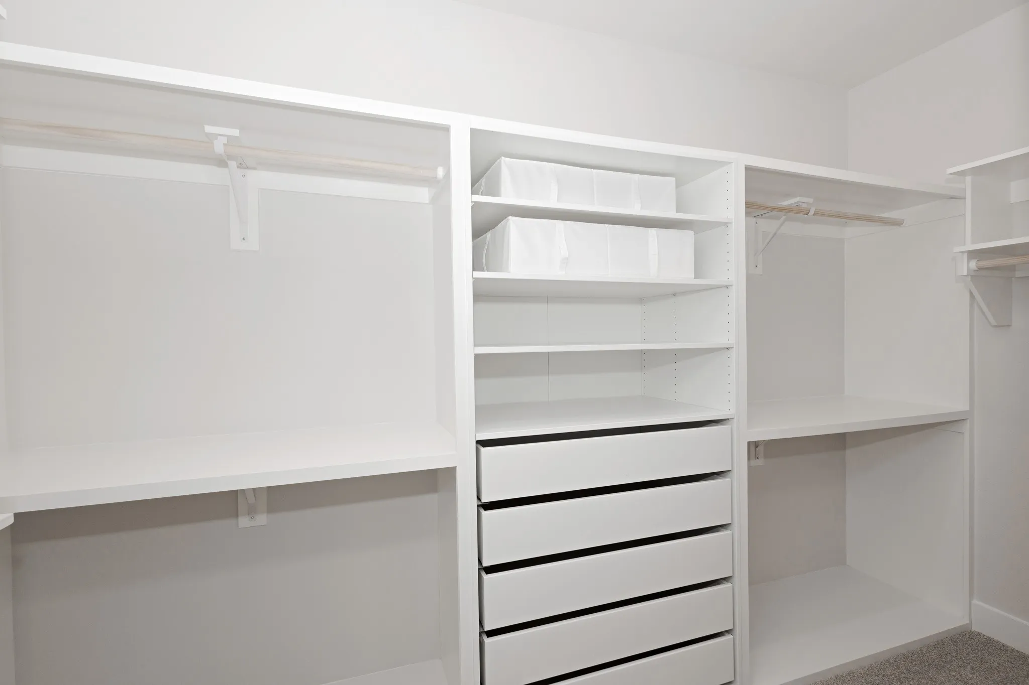 A thoughtfully designed Walk-In Custom Closet System with Soft Close Drawers, Shelving, and a Wall of Shelving (not pictured).