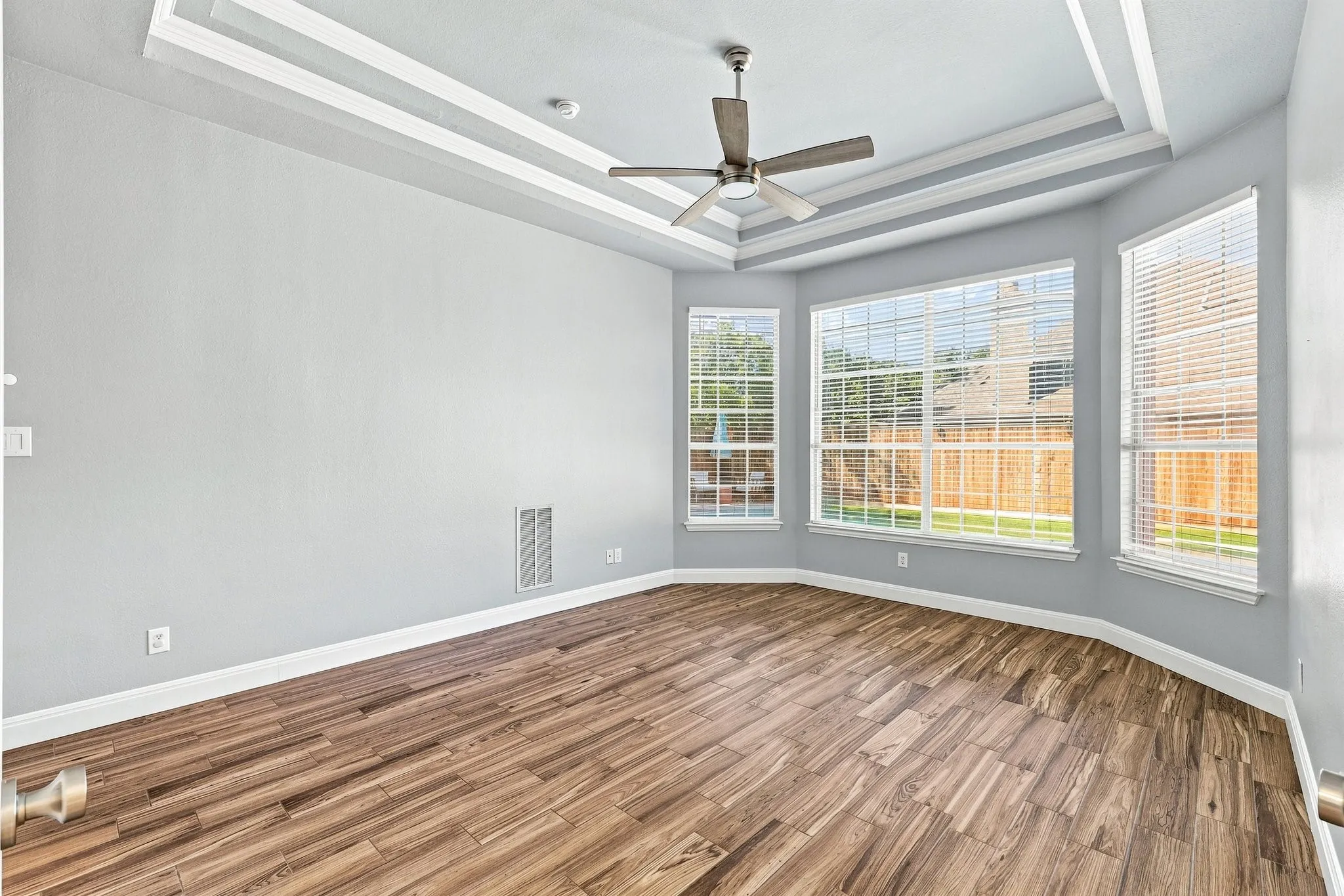 The Primary Bedroom located on first floor has amazing windows and decorative ceiling accents.