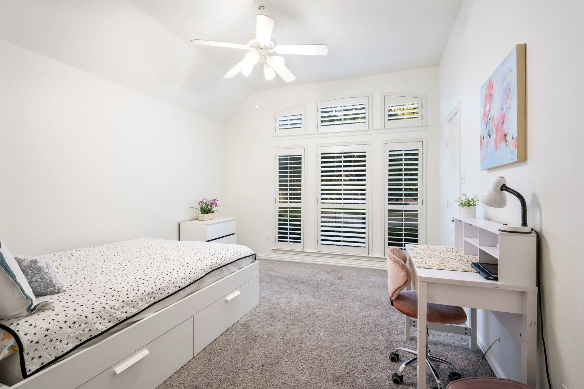 Secondary bedroom down has lots of room for sleep and play, plus a desk. Built in closet . Energy efficient fan and light, and plantation shutters.