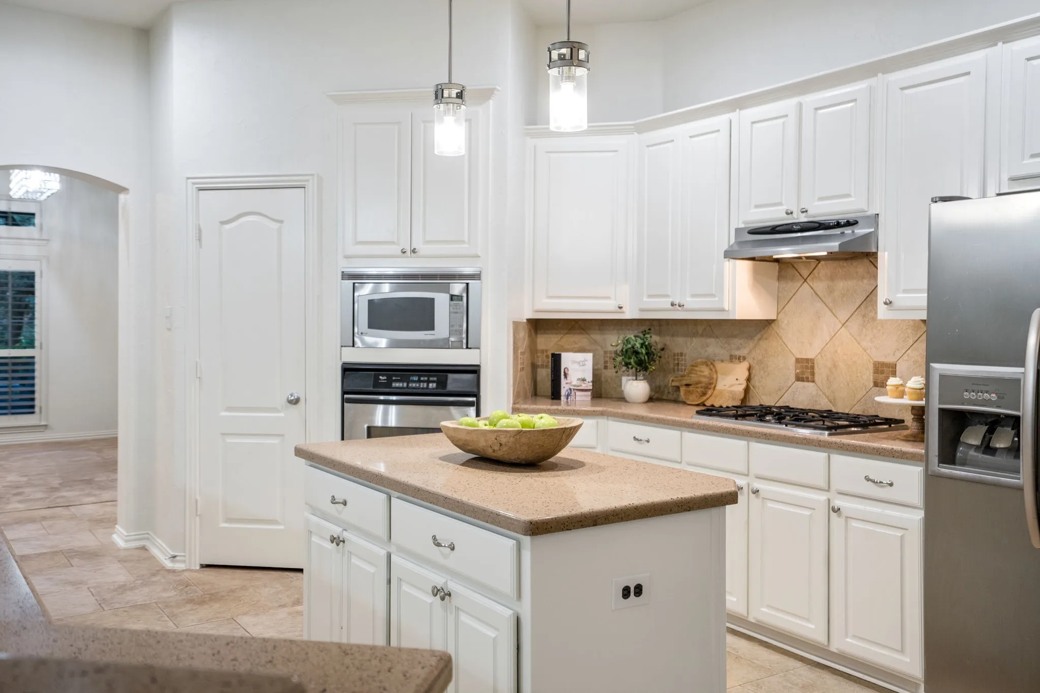 Gas cooktop and stainless oven and microwave, double sink, island, kitchen bar, dine in kitchen nook, brand newly painted kitchen cabinetry, updated brand new Williams Sonoma light in eat in kitchen, large pantry, lots of cabinetry, stainless dishwasher. Fridge is not included.