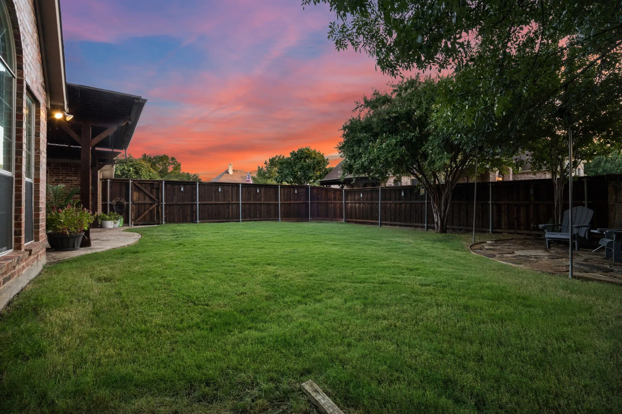 Well appointed yard with wooden fence, trees, and a beautiful nature shot of your view of the Texas Sunset!