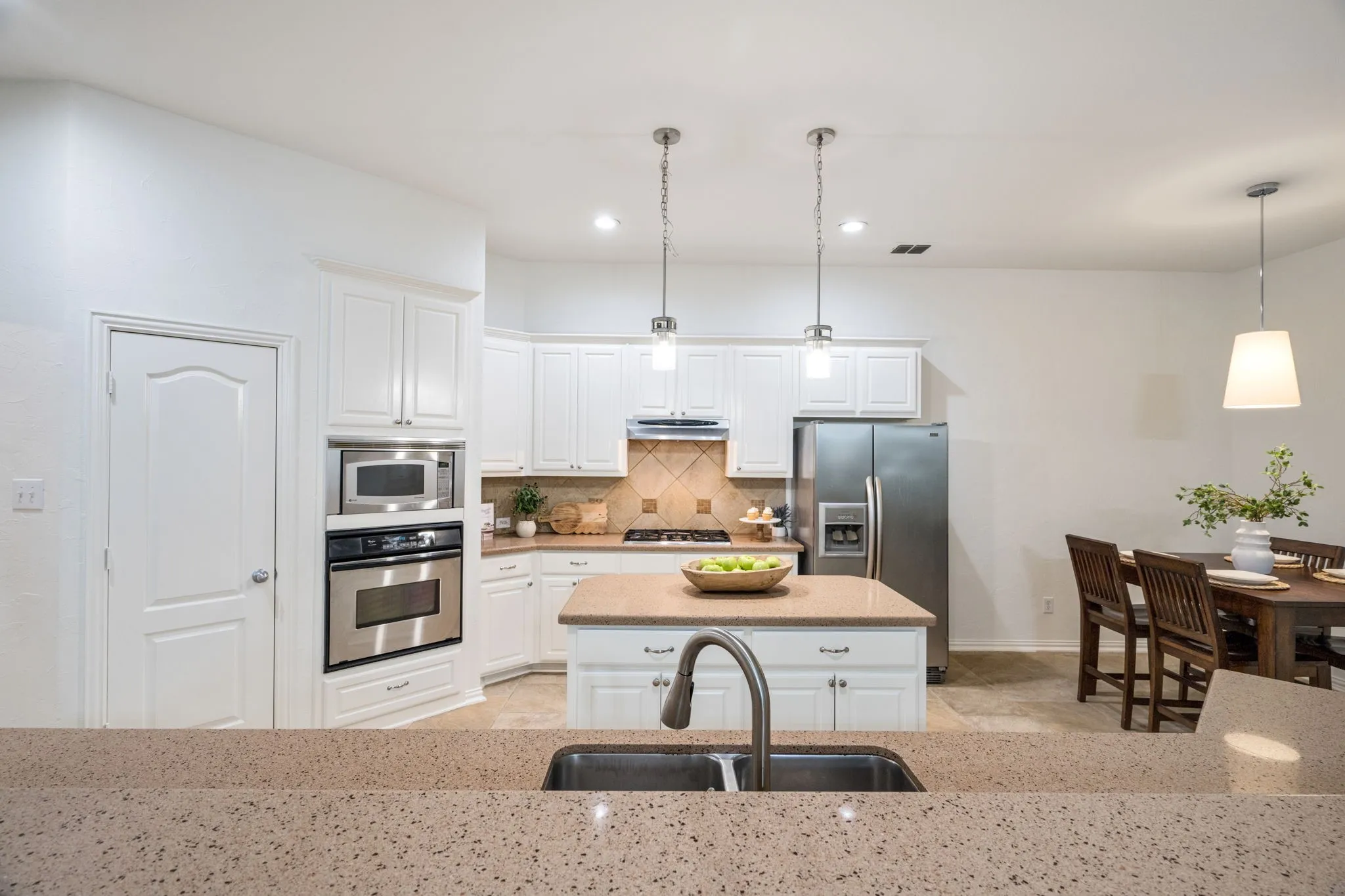 Huge kitchen with a long island for all the gatherings and an island plus an eat in kitchen table allows for all of the room to really host in the heart of the home in this kitchen that has been repainted SW Alabaster White. Brand new Williams Sonoma cone lamp over the dining table!