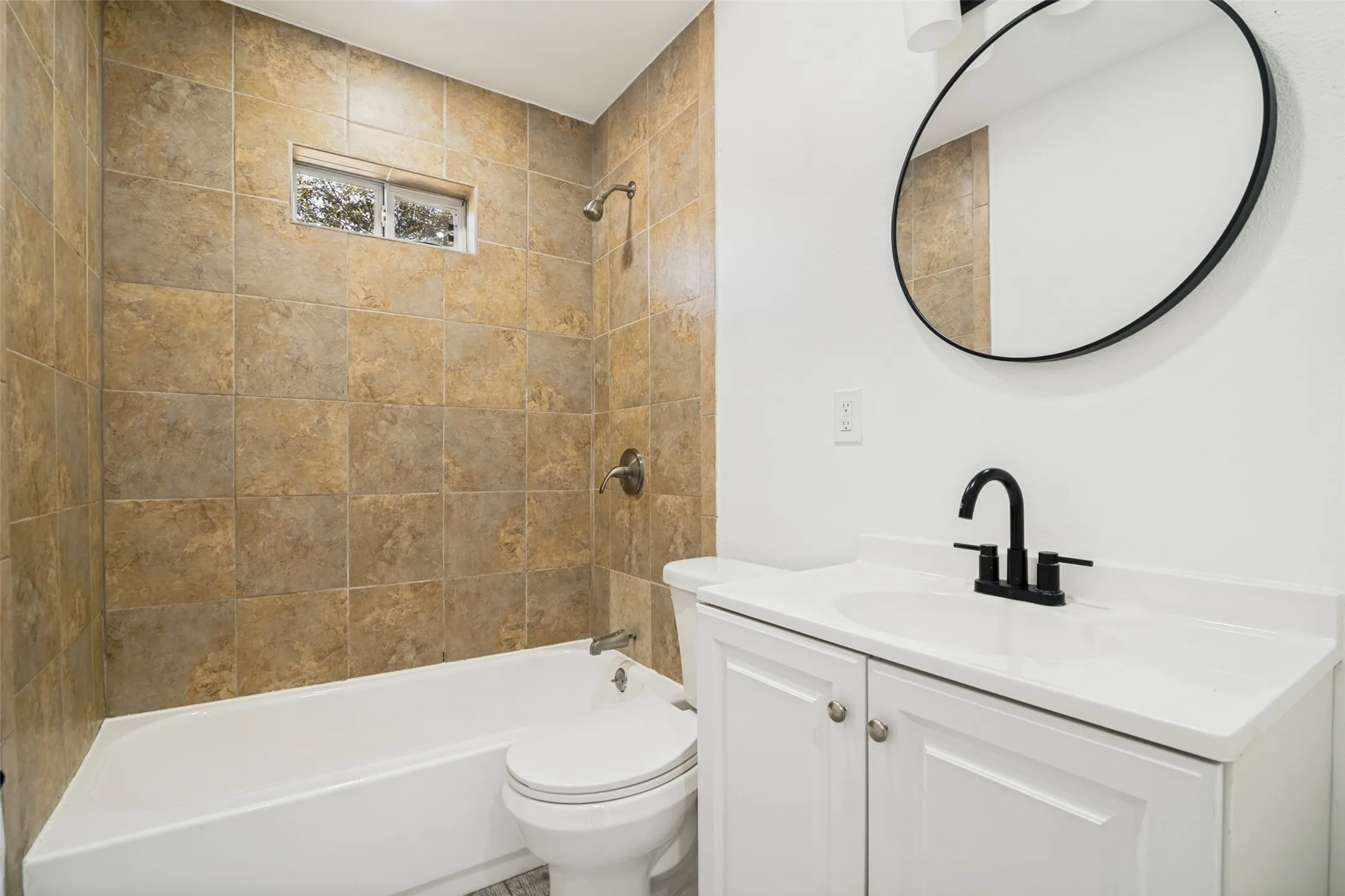 Built-in bathtub with a shower, floor-to-ceiling tile surround, and a privacy window