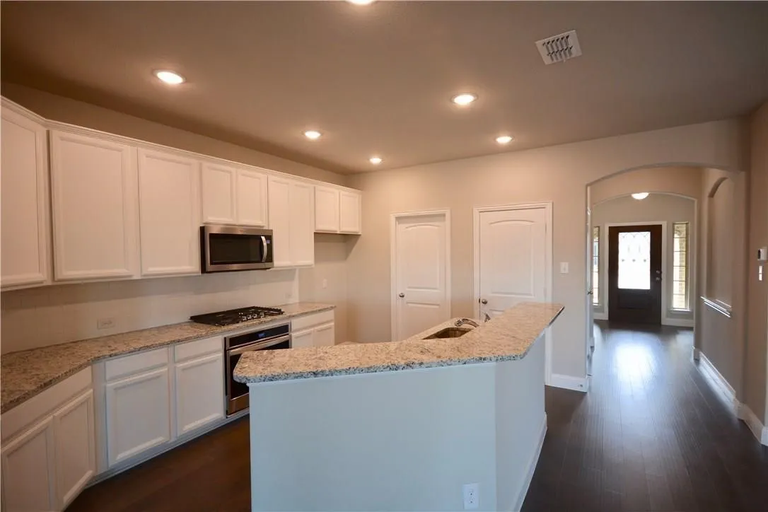 Kitchen featuring white cabinetry, light-toned countertops, and stainless steel appliances
