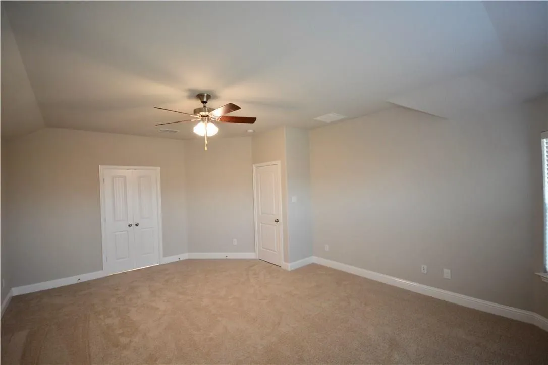 Carpeted flooring, ceiling fan with integrated lighting, double-door closet, and window with horizontal blinds
