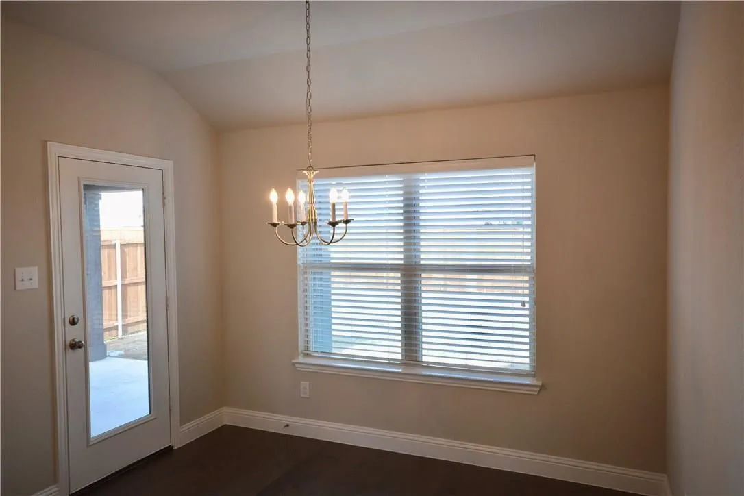 Recessed ceiling, neutral wall paint, overhead chandelier, window with blinds, and white trim