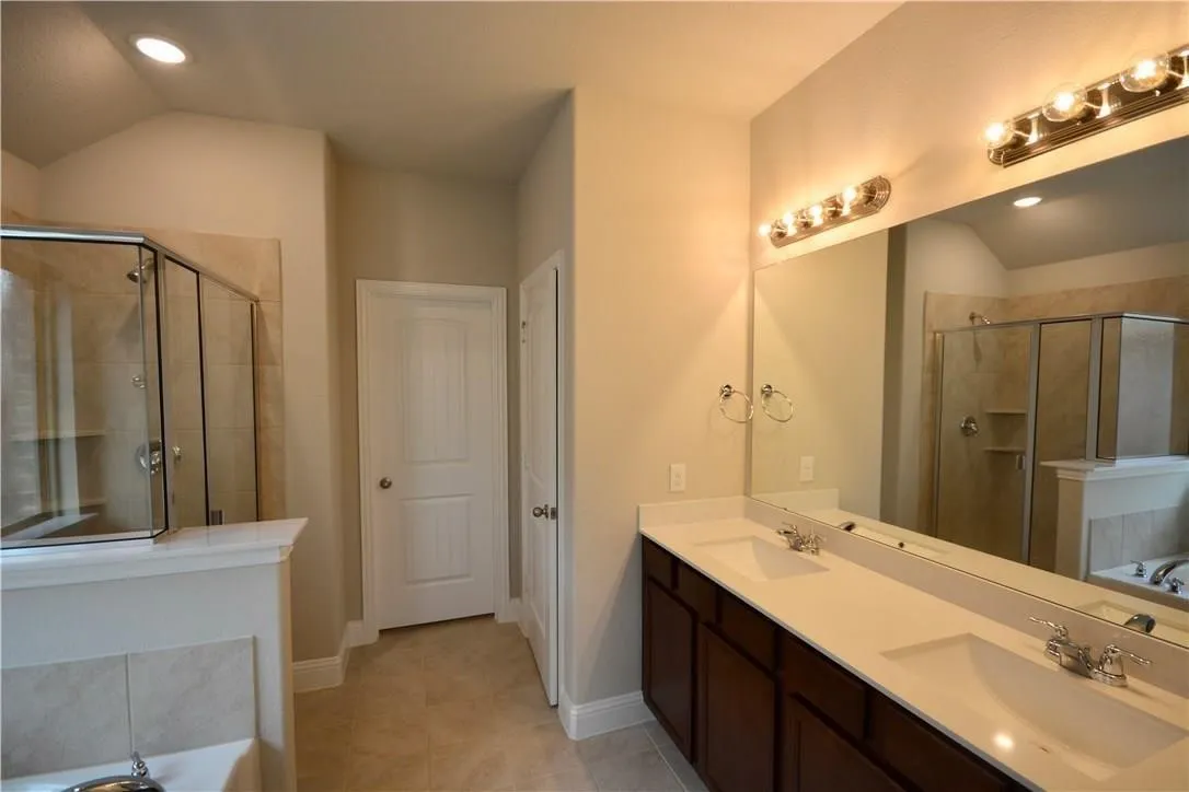 Dual vanity with white countertops, dark wood-finish cabinetry, and chrome fixtures