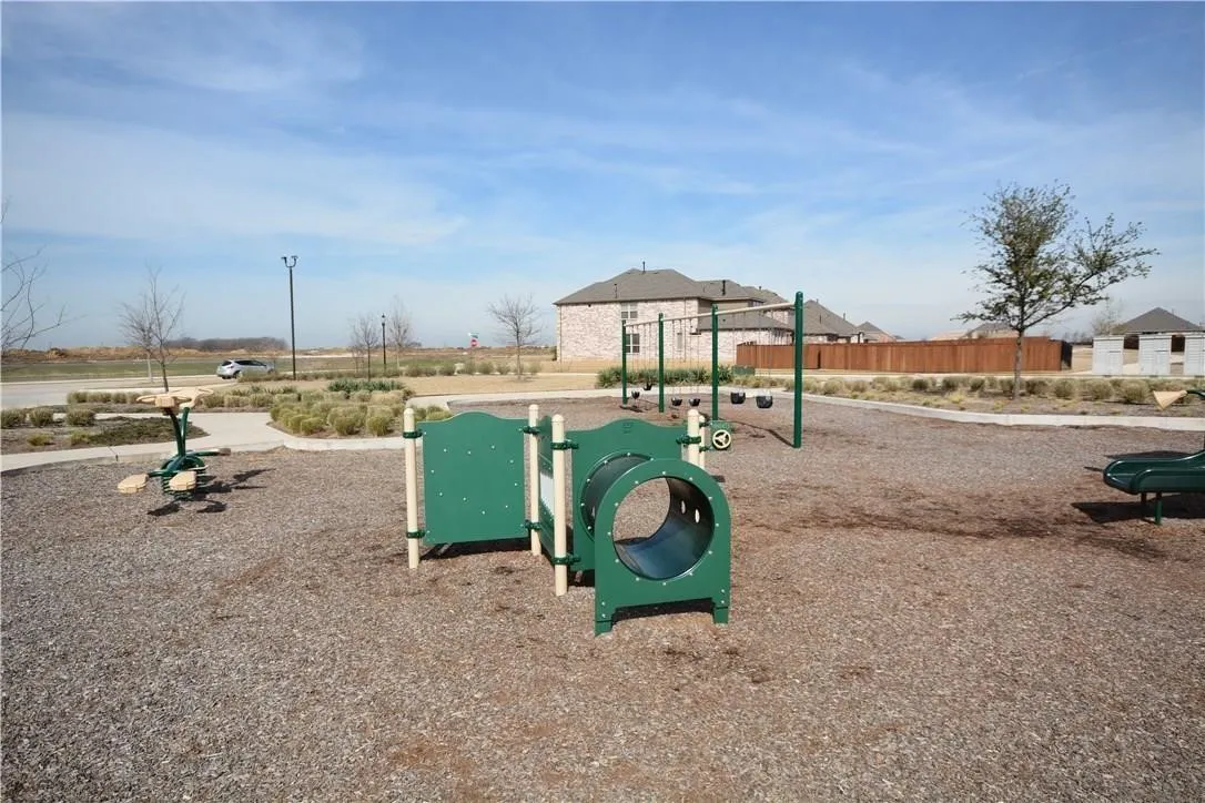 Playground area featuring multiple play structures, a swing set, and a tunnel component