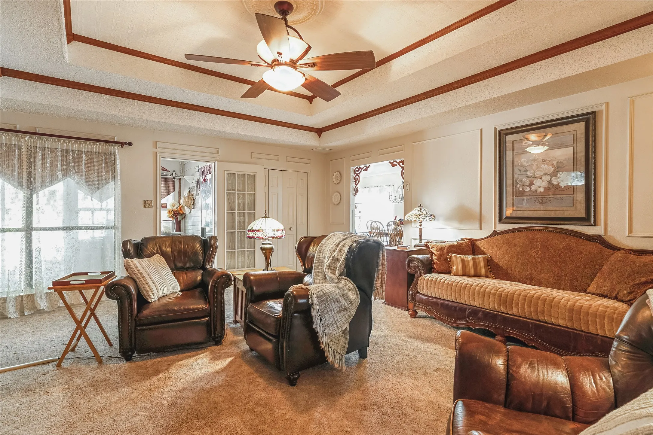 Tray ceiling with wood-finish trim and a ceiling fan