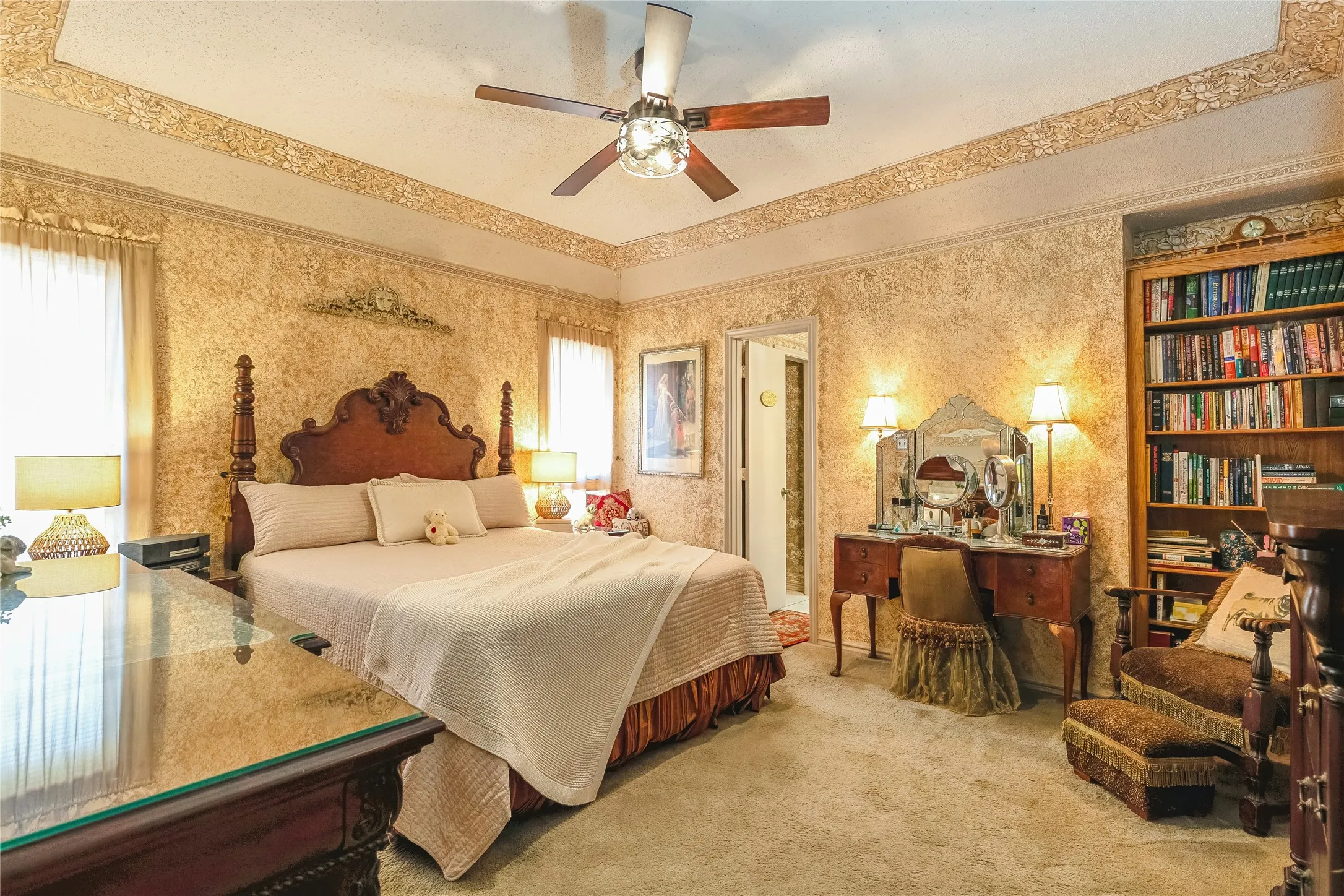 Tray ceiling with decorative molding, built-in shelving, ornate wall finish, recessed lighting, and a ceiling fan with light fixture