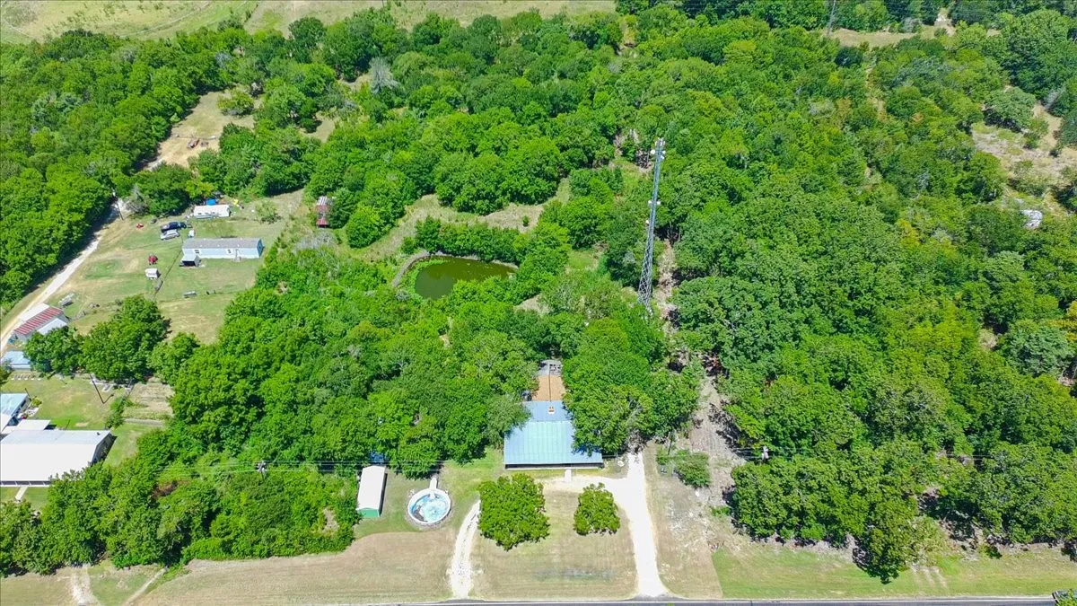 Expansive treed parcel with a pond and multiple structures
