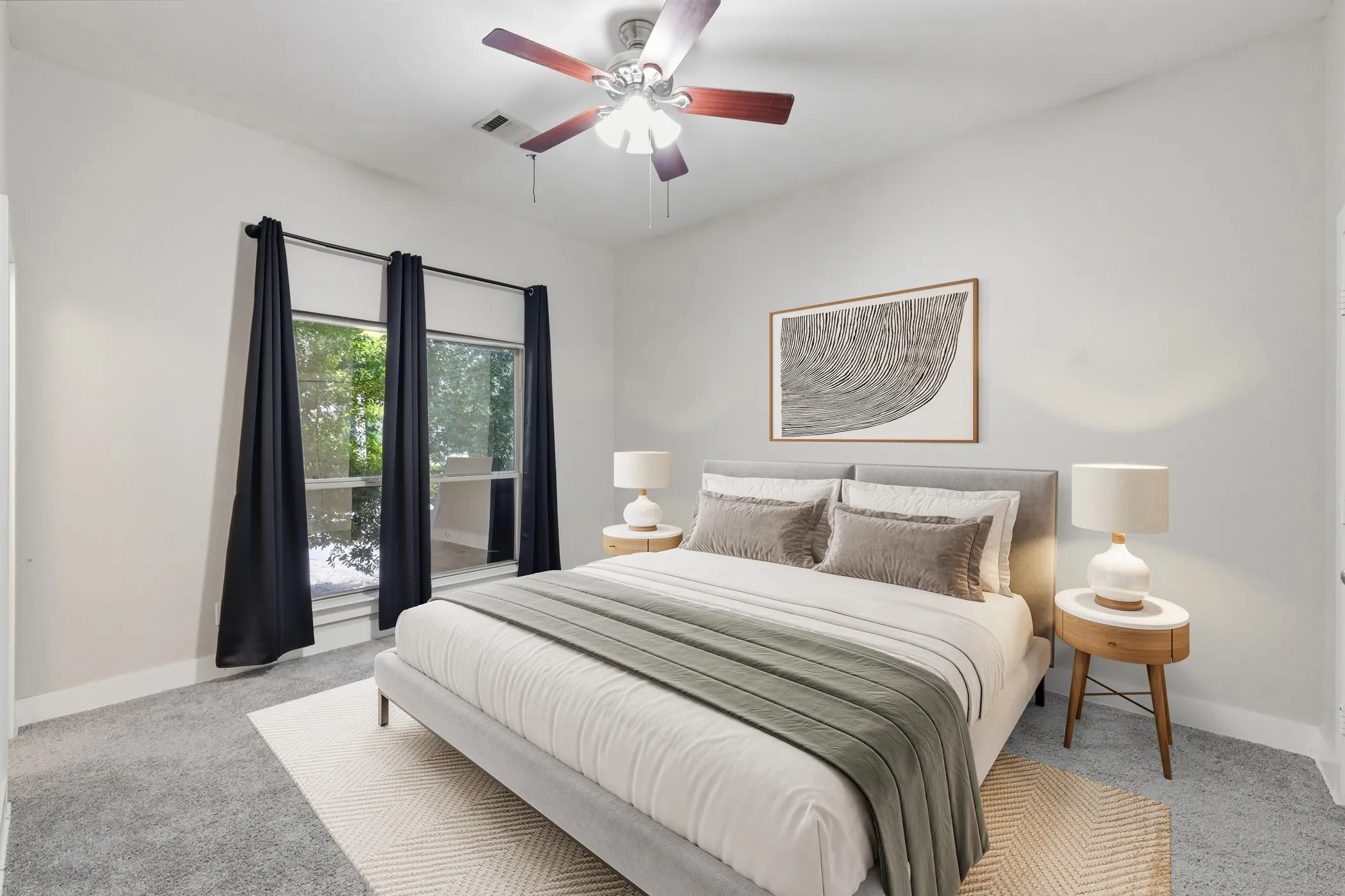 Large windows, ceiling fan, and light gray wall paint