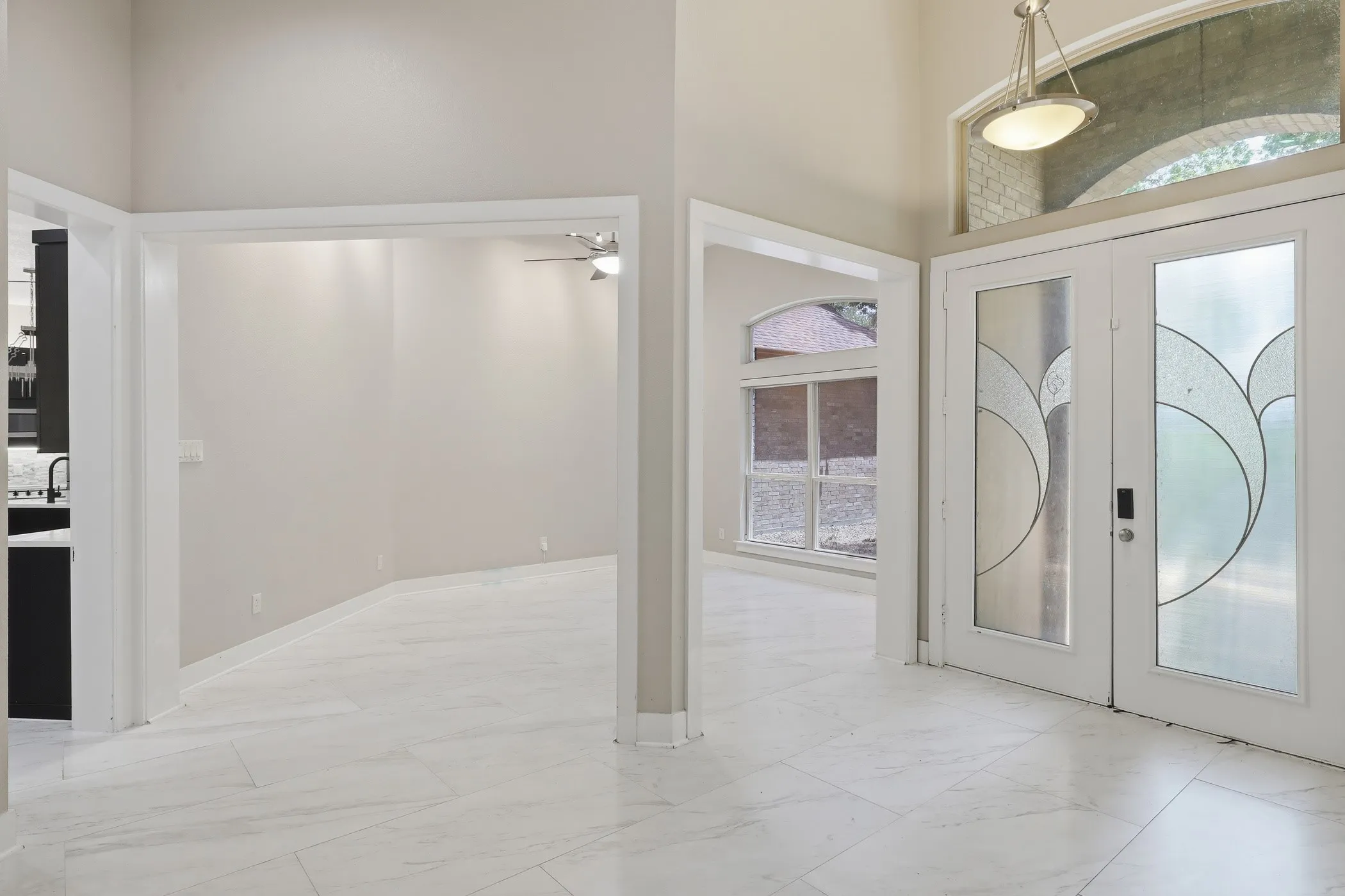 Double entry doors with decorative glass panels, transom window, and overhead lighting fixture