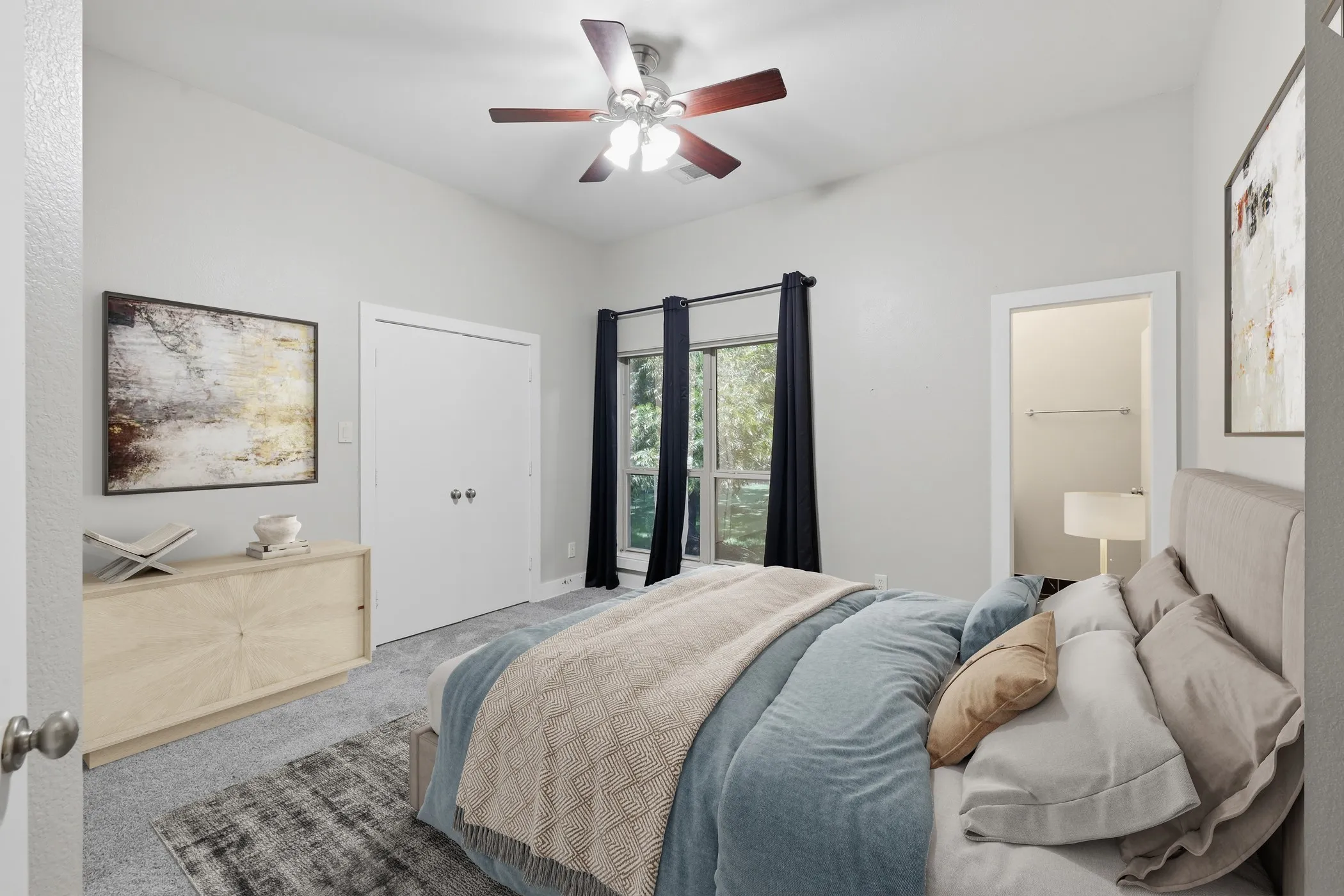 Vaulted ceiling with a ceiling fan, carpeted flooring, double-door closet, and window with dark drapery