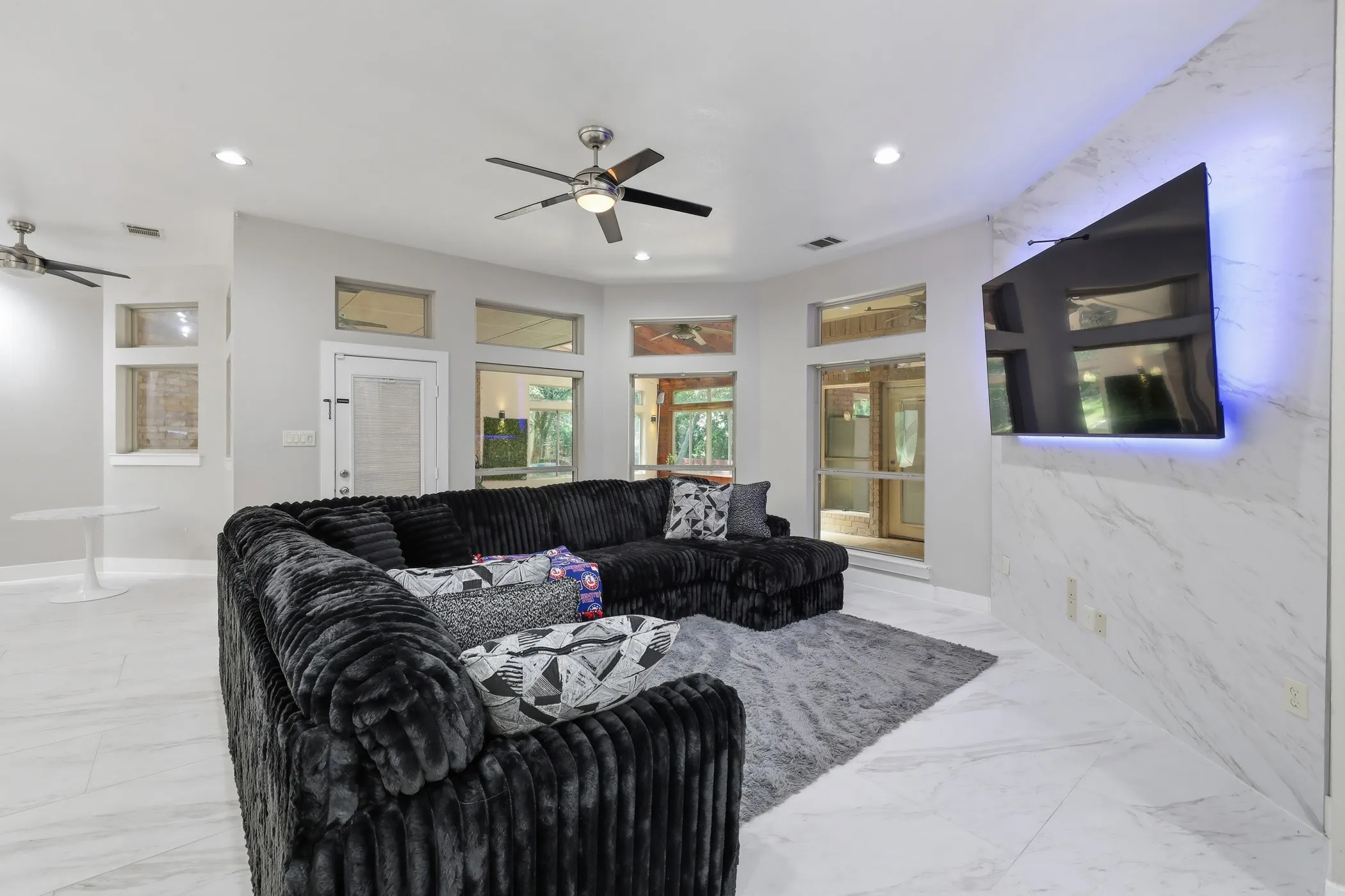 Recessed lighting, ceiling fans, tiled flooring, and a wall-mounted entertainment feature