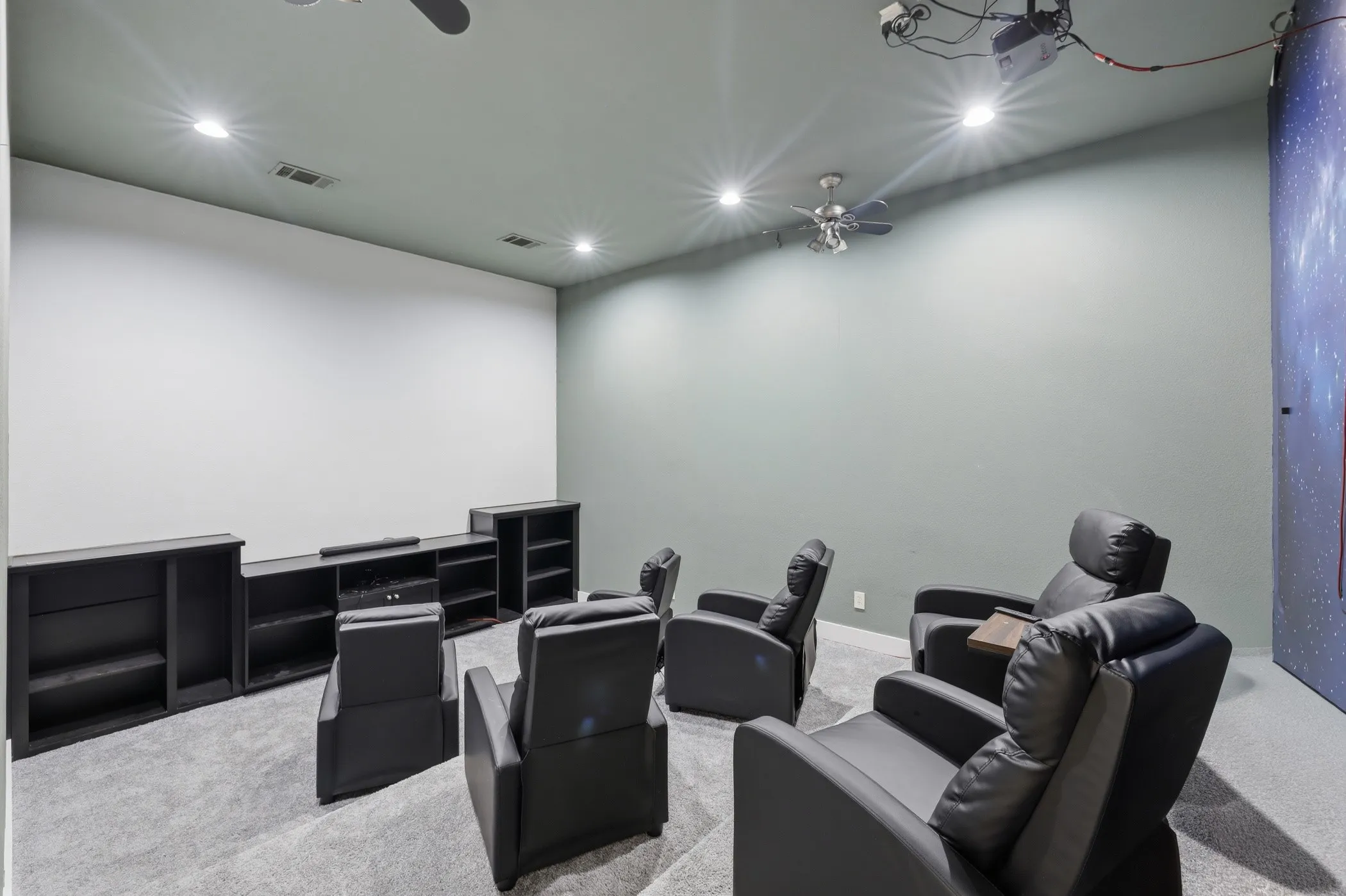 Recessed ceiling lighting, ceiling-mounted projector, wall-mounted projection screen, and built-in shelving
