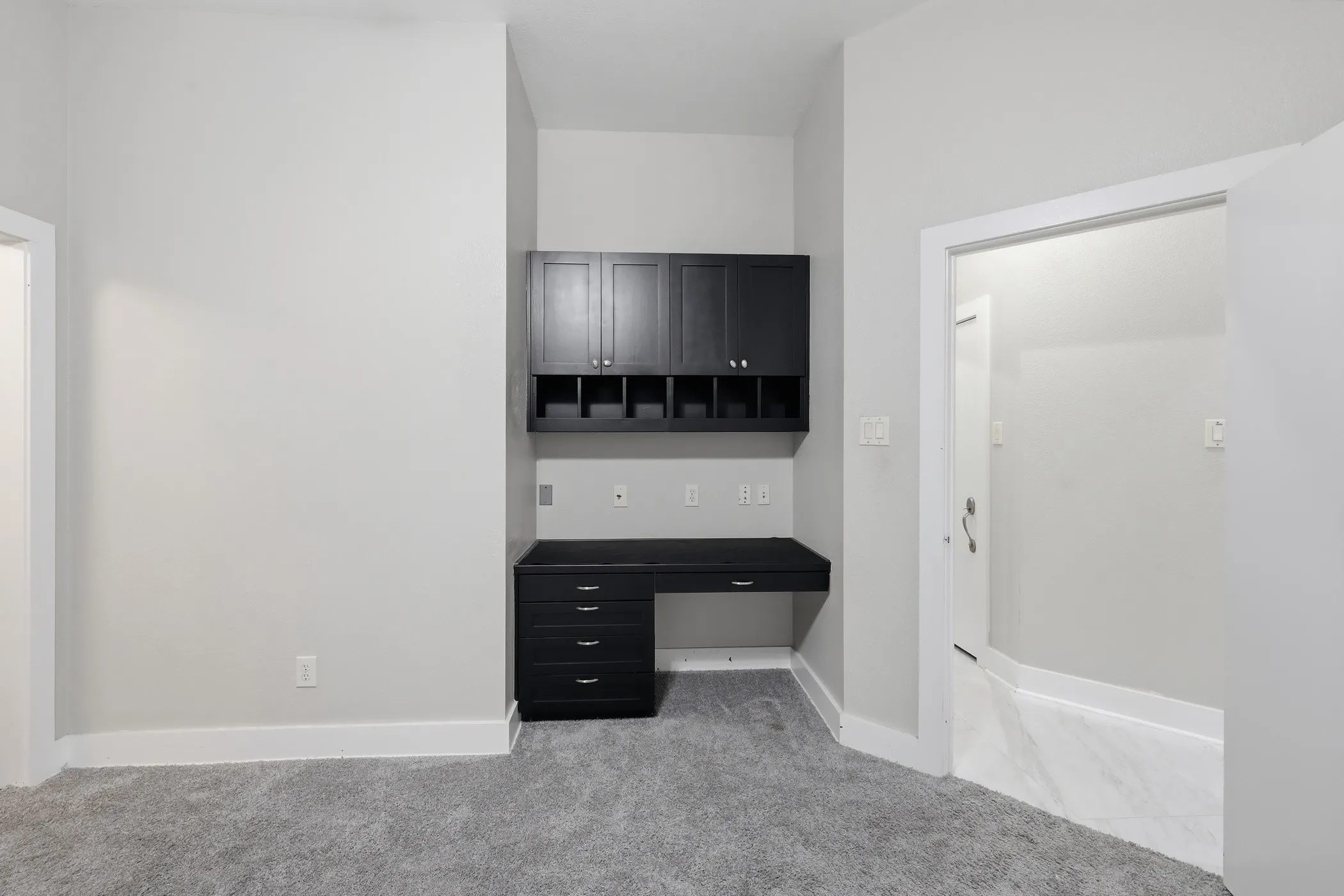 Built-in desk with black cabinetry, integrated shelving, and a coordinating countertop