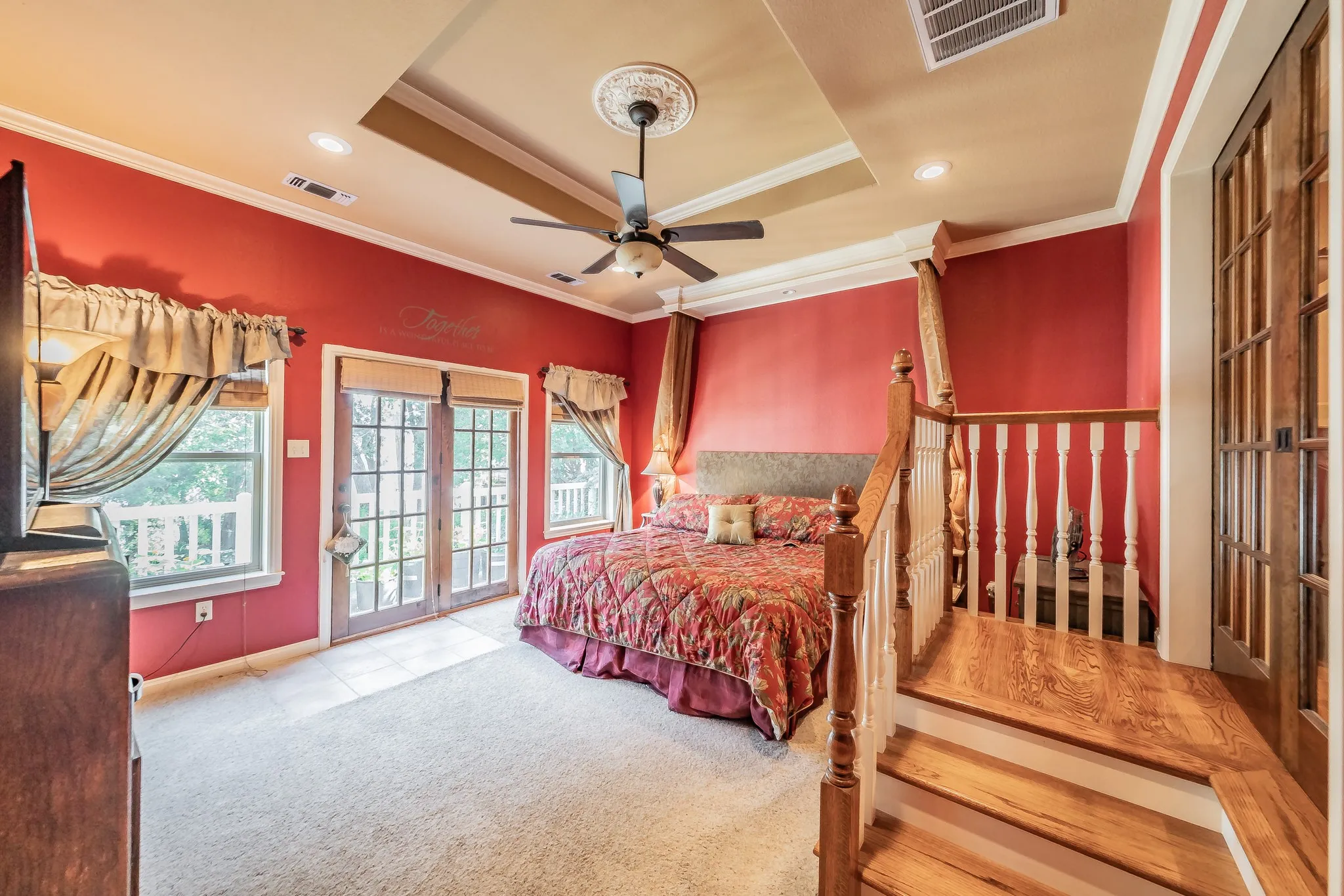 Carpeted bedroom with a raised ceiling, custom wood crown molding, access to exterior, a ceiling fan, and recessed lighting
