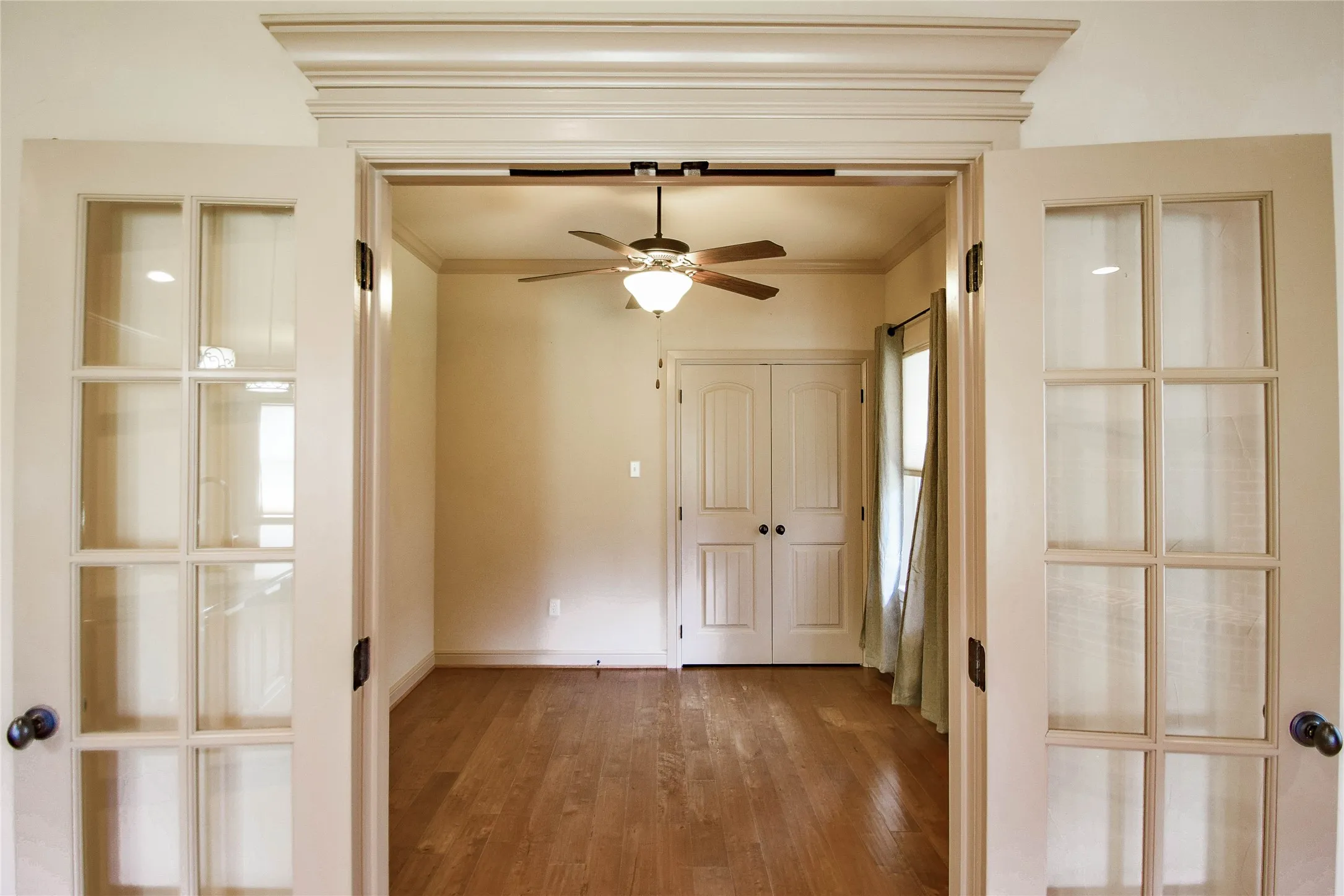 3rd bedroom or study with wood floors and french doors