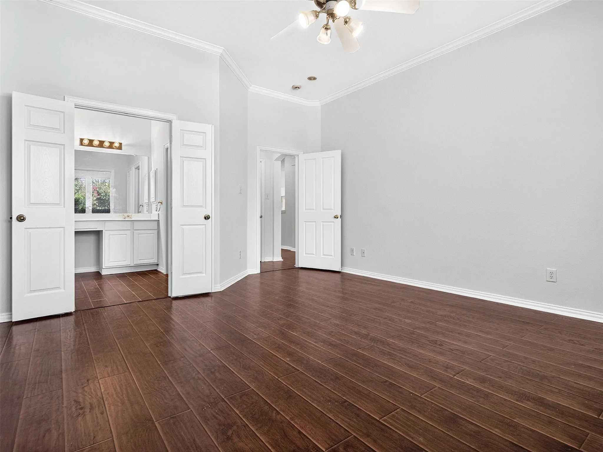 Wood-finish flooring throughout, bright walls, and crown molding
