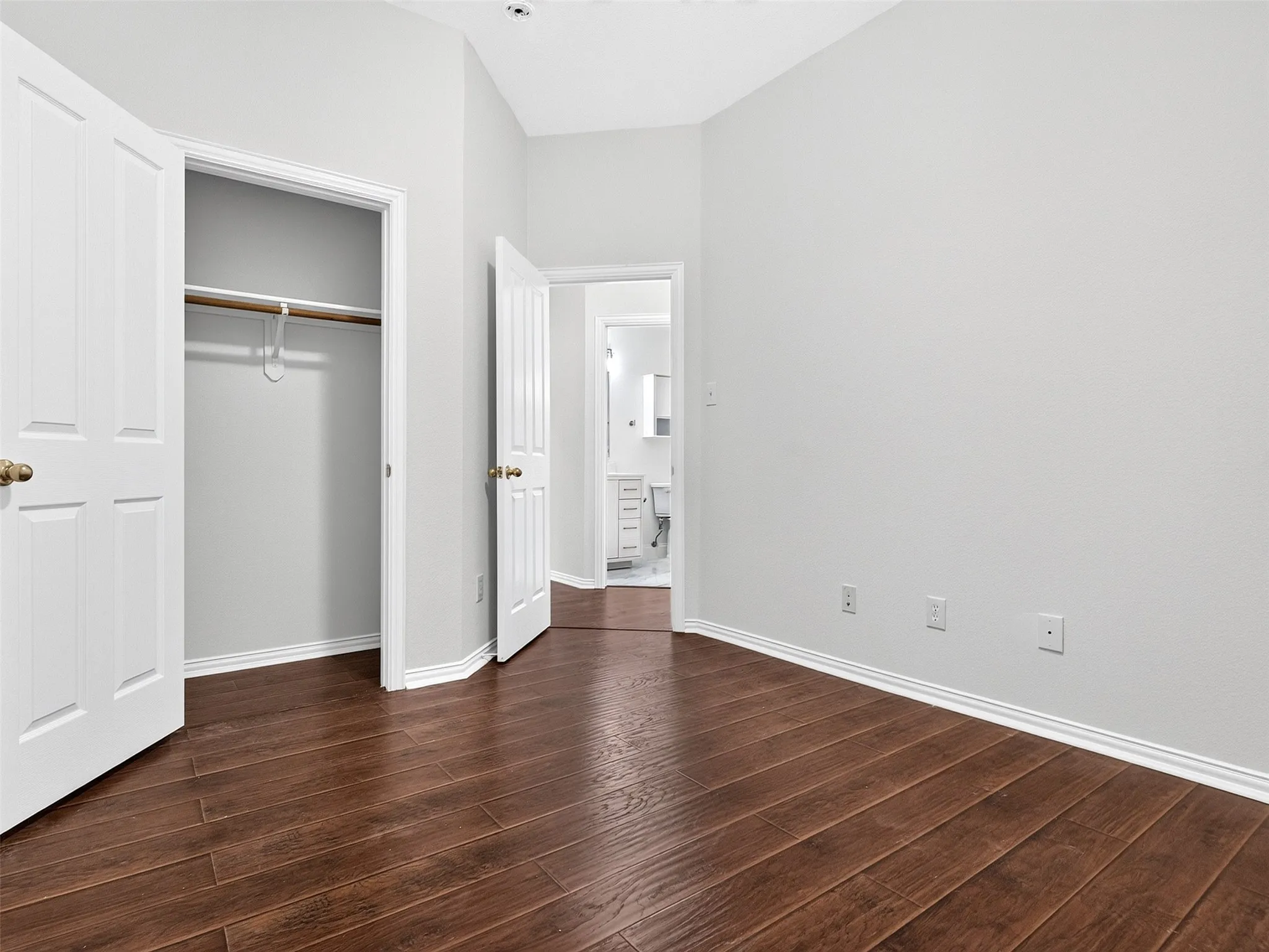 Wood-finish flooring throughout, white trim, and a built-in closet with double doors