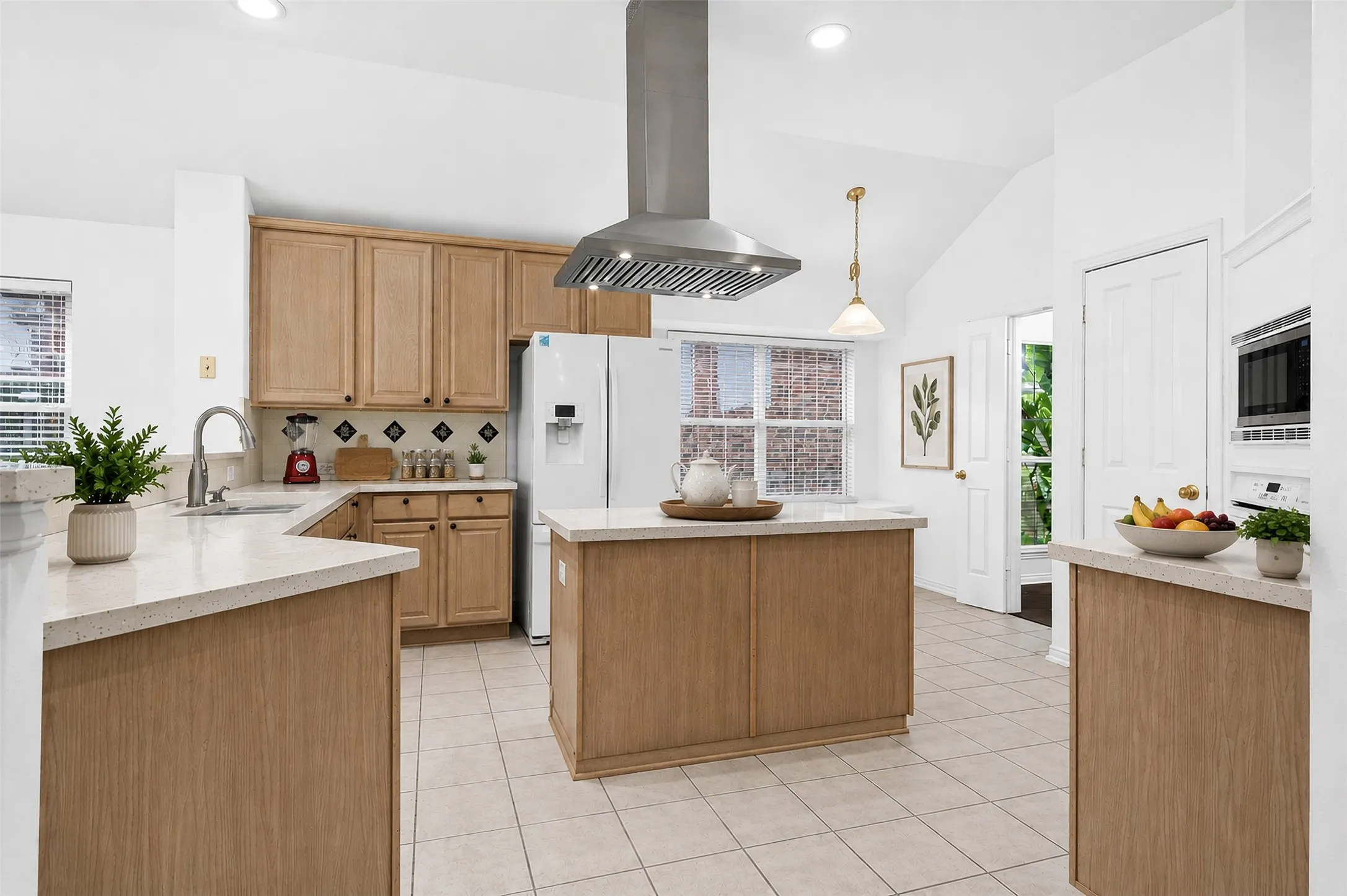 Kitchen featuring a vaulted ceiling, recessed lighting, wood cabinetry, light-toned countertops, and a stainless steel range hood