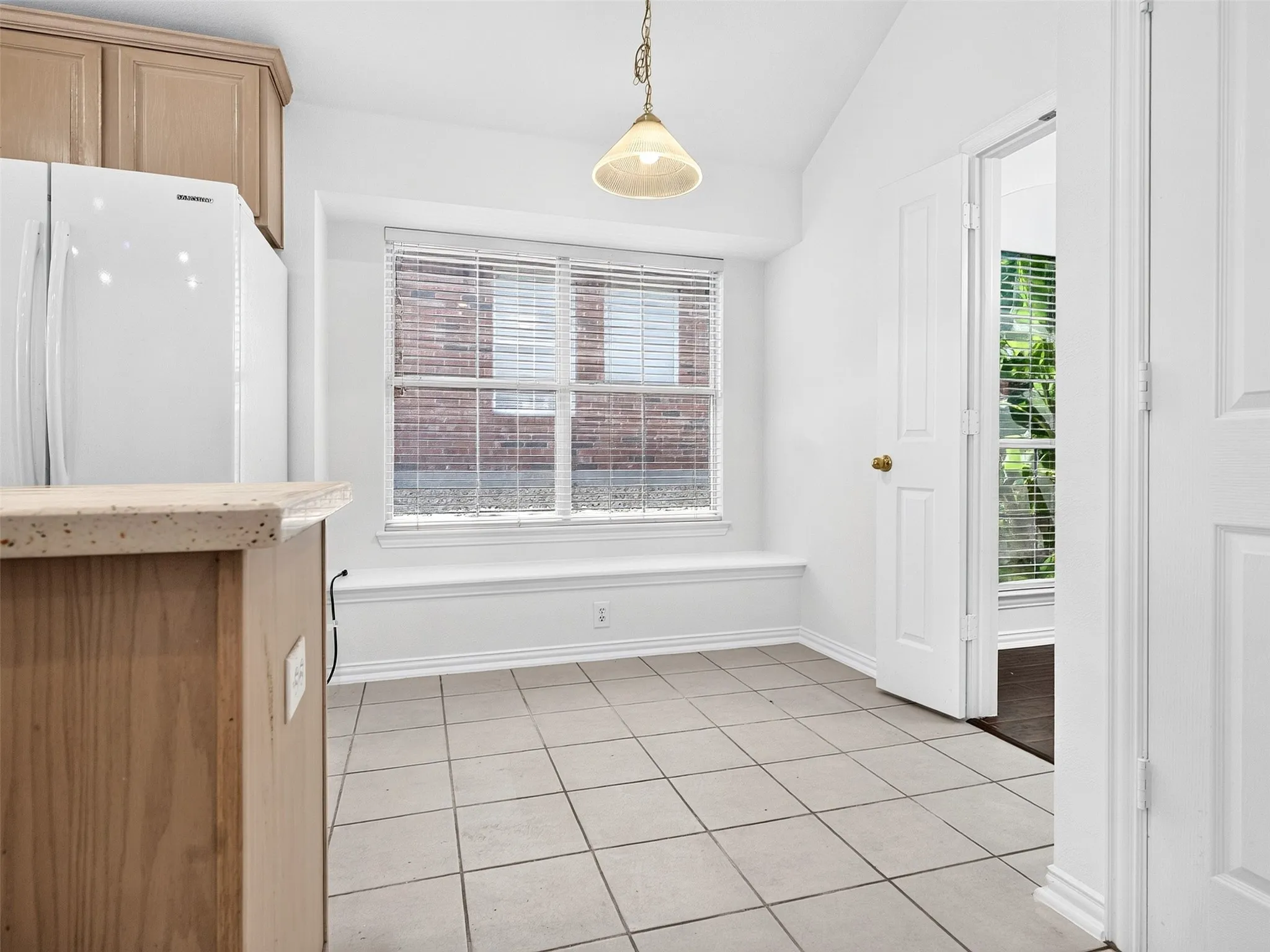 Bay window with integrated bench, ceramic tile flooring, built-in cabinetry, and white interior doors