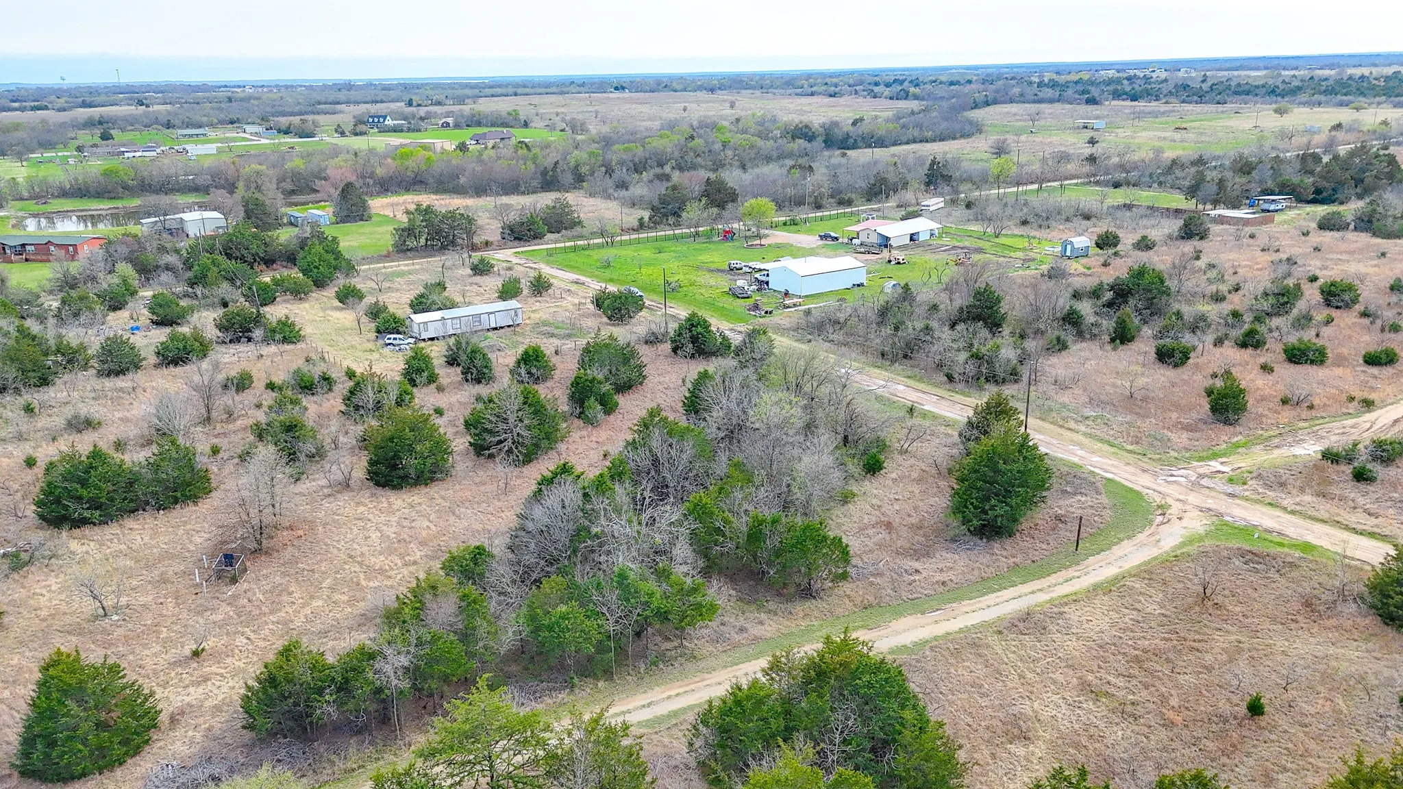 Expansive rural landscape featuring scattered trees and multiple unpaved access roads