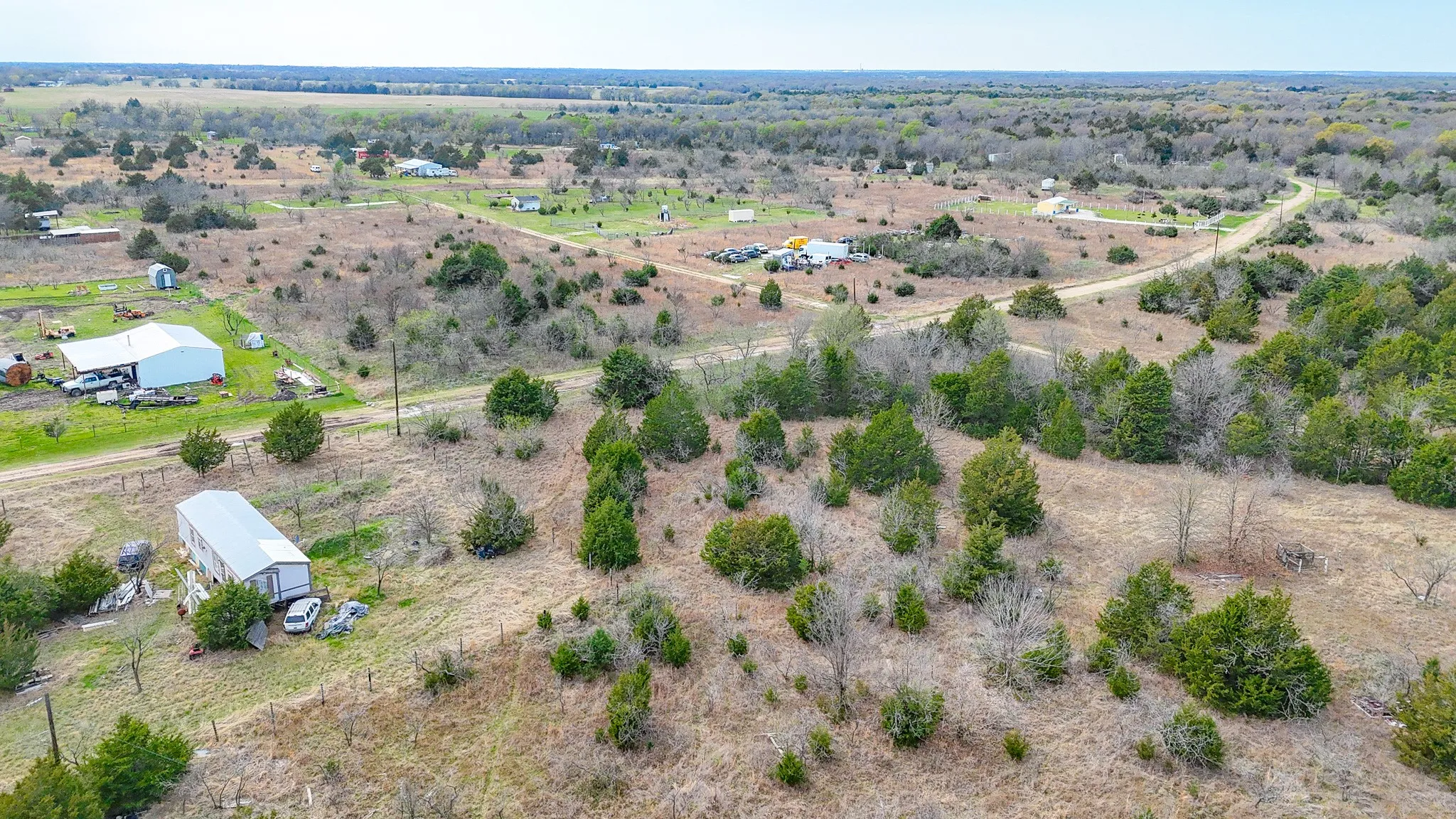 Expansive rural landscape featuring scattered trees and open fields