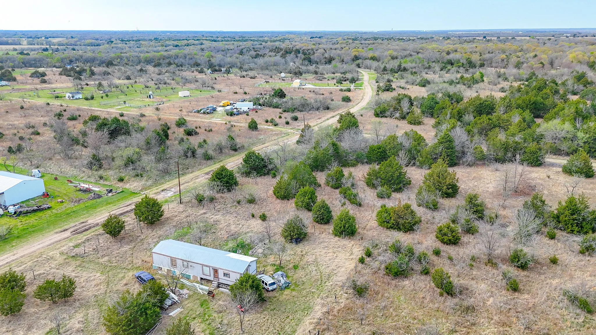 Expansive land parcel featuring scattered trees and established roads