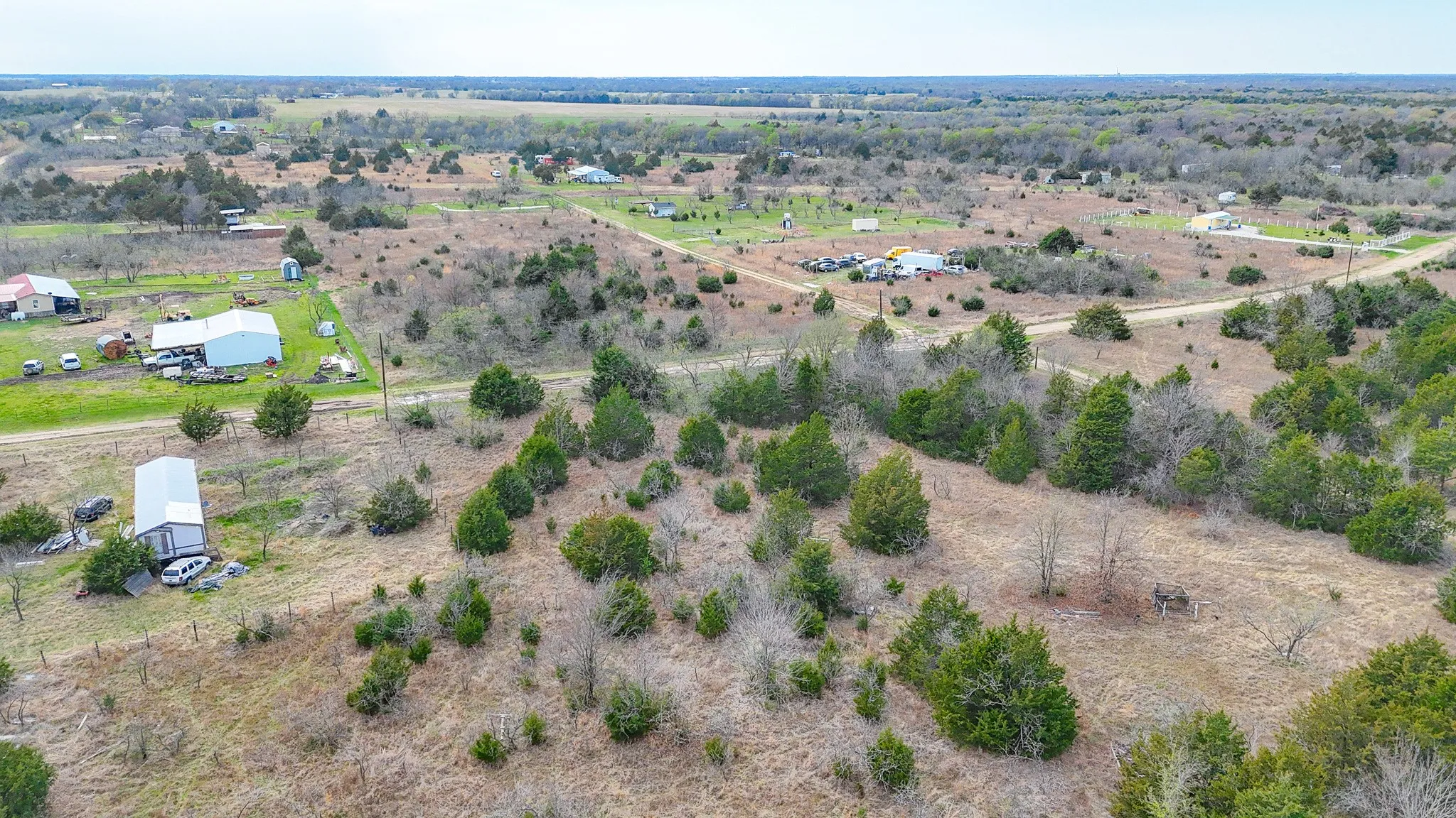 Expansive, undeveloped terrain featuring scattered trees and established roads