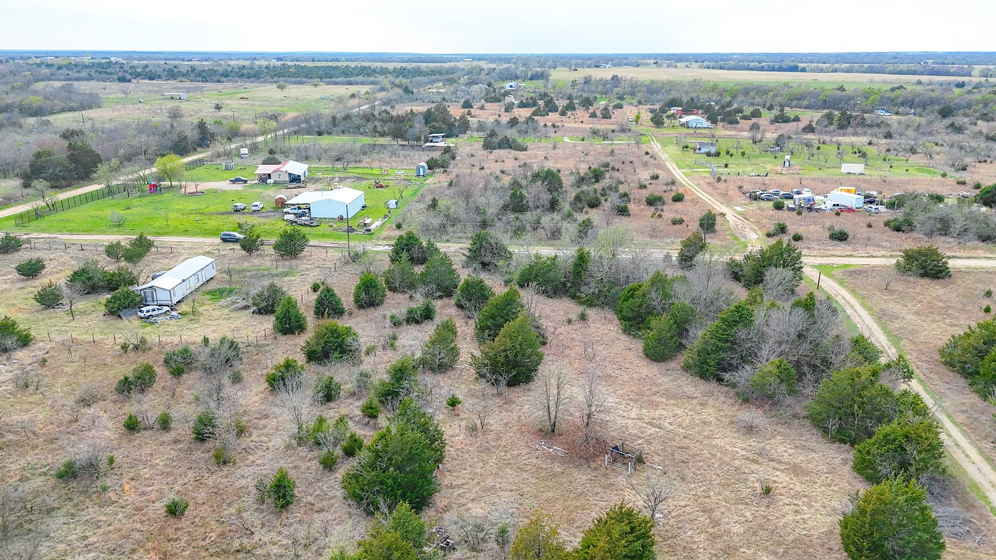 Expansive rural property featuring multiple structures, open land, and scattered trees