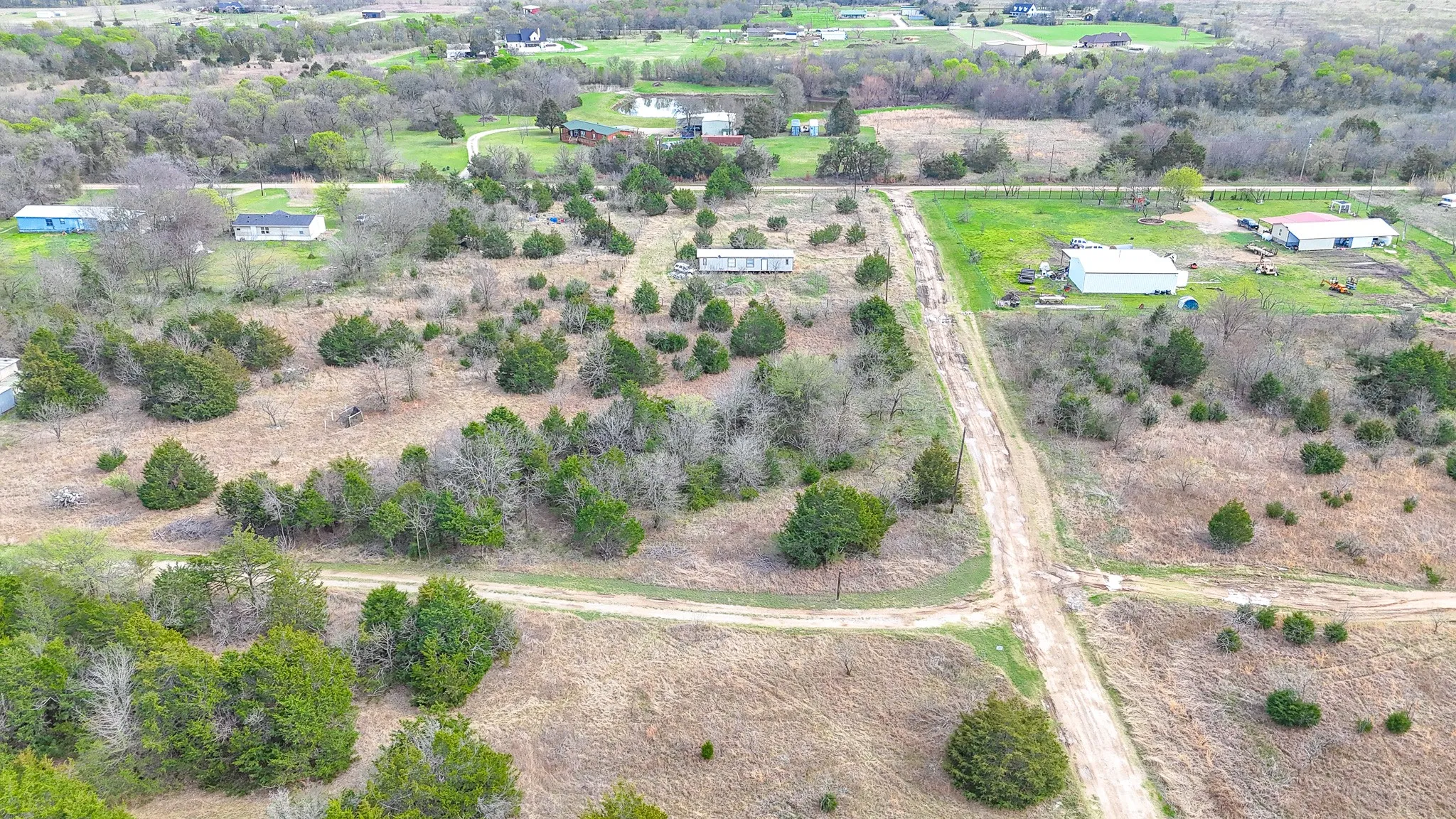 Expansive rural property featuring multiple residential structures, undeveloped land, and established natural areas