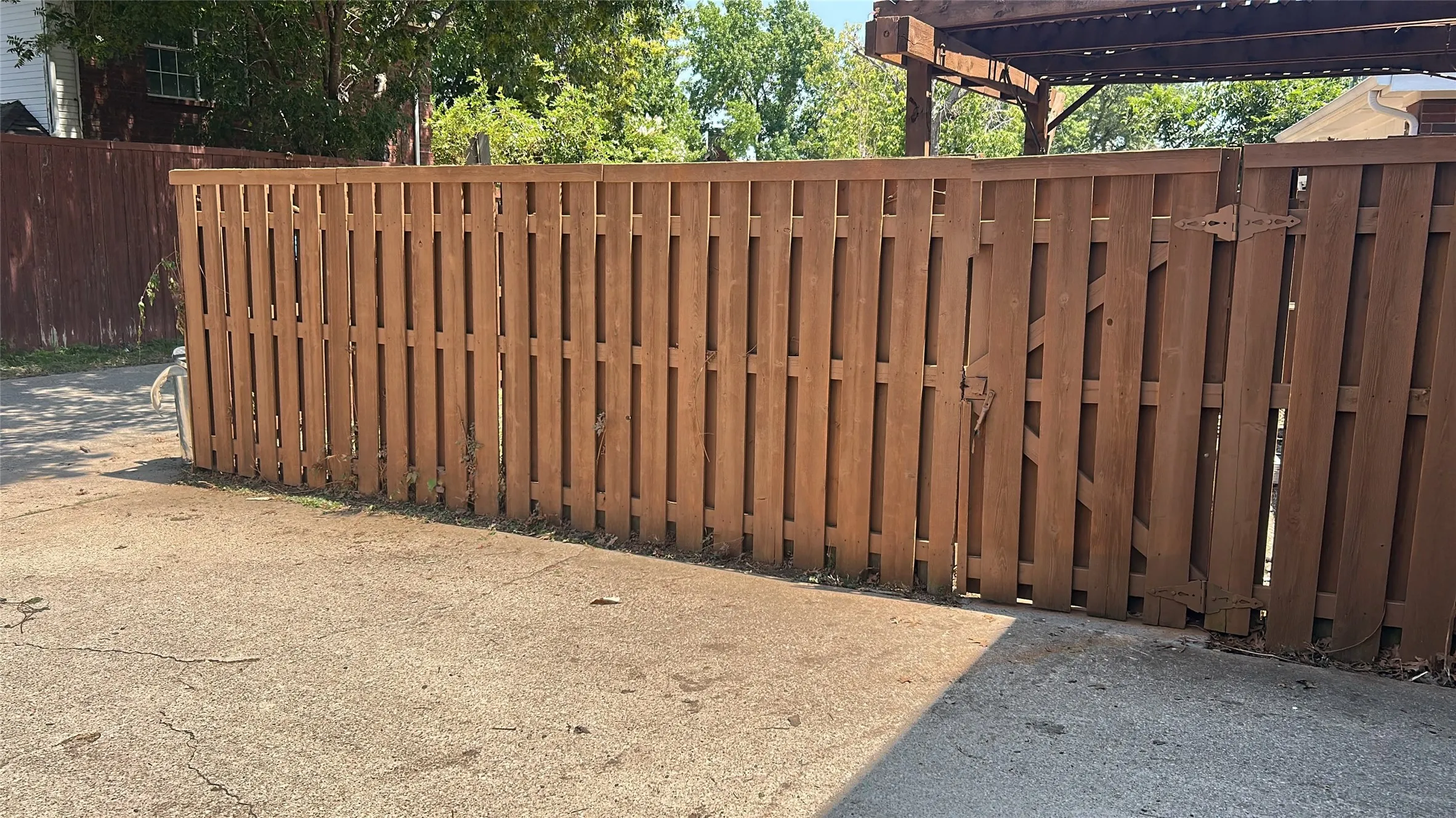 Wooden privacy fence with a double gate and dark brown hardware
