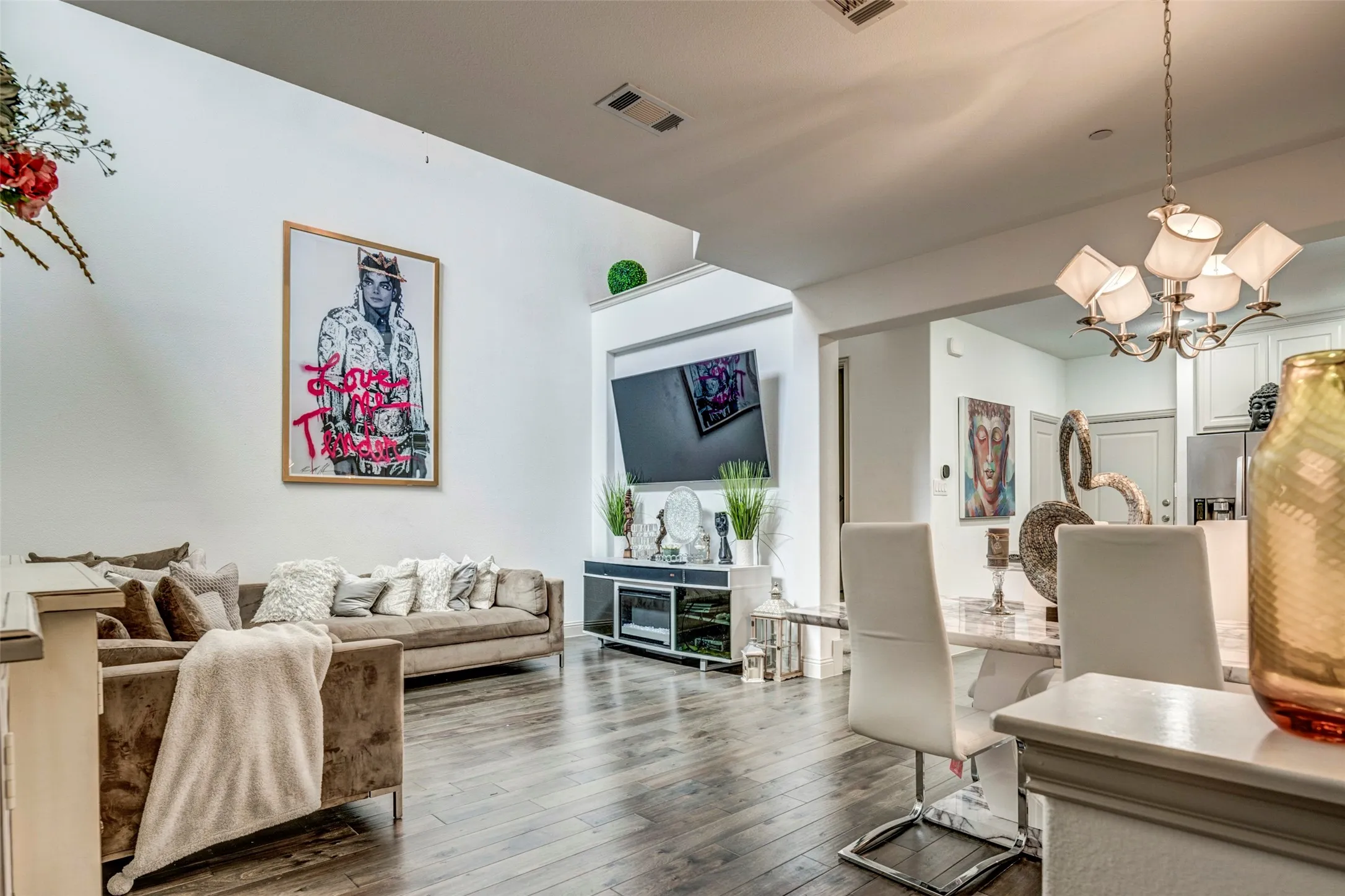 Vaulted ceiling living area featuring wood-finish flooring