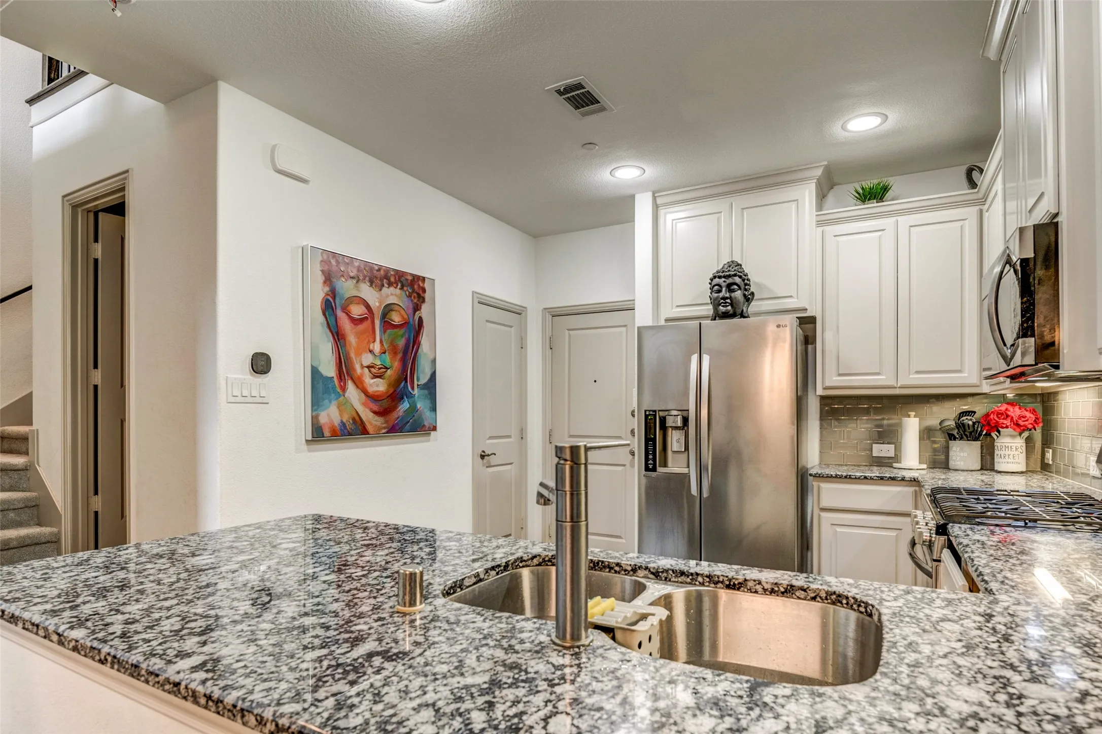 Kitchen featuring granite countertops, stainless steel appliances, recessed lighting, white shaker-style cabinetry, and a tile backsplash