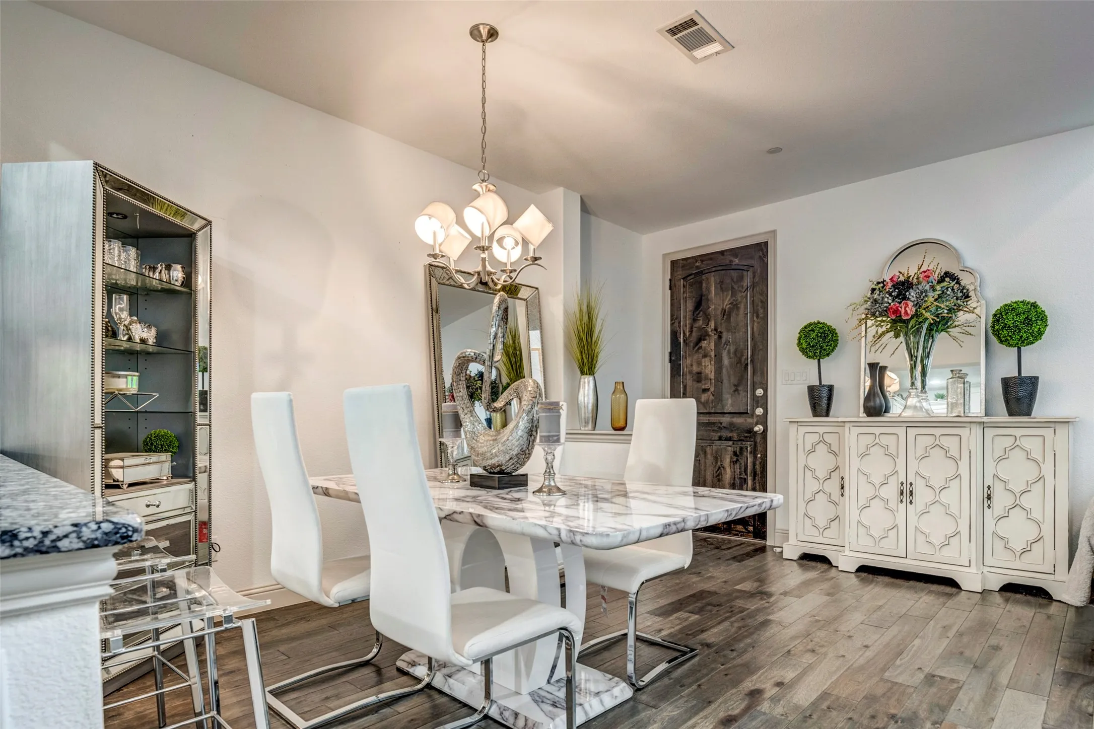 Open-concept dining area featuring wood-finish flooring, recessed lighting, and a chandelier