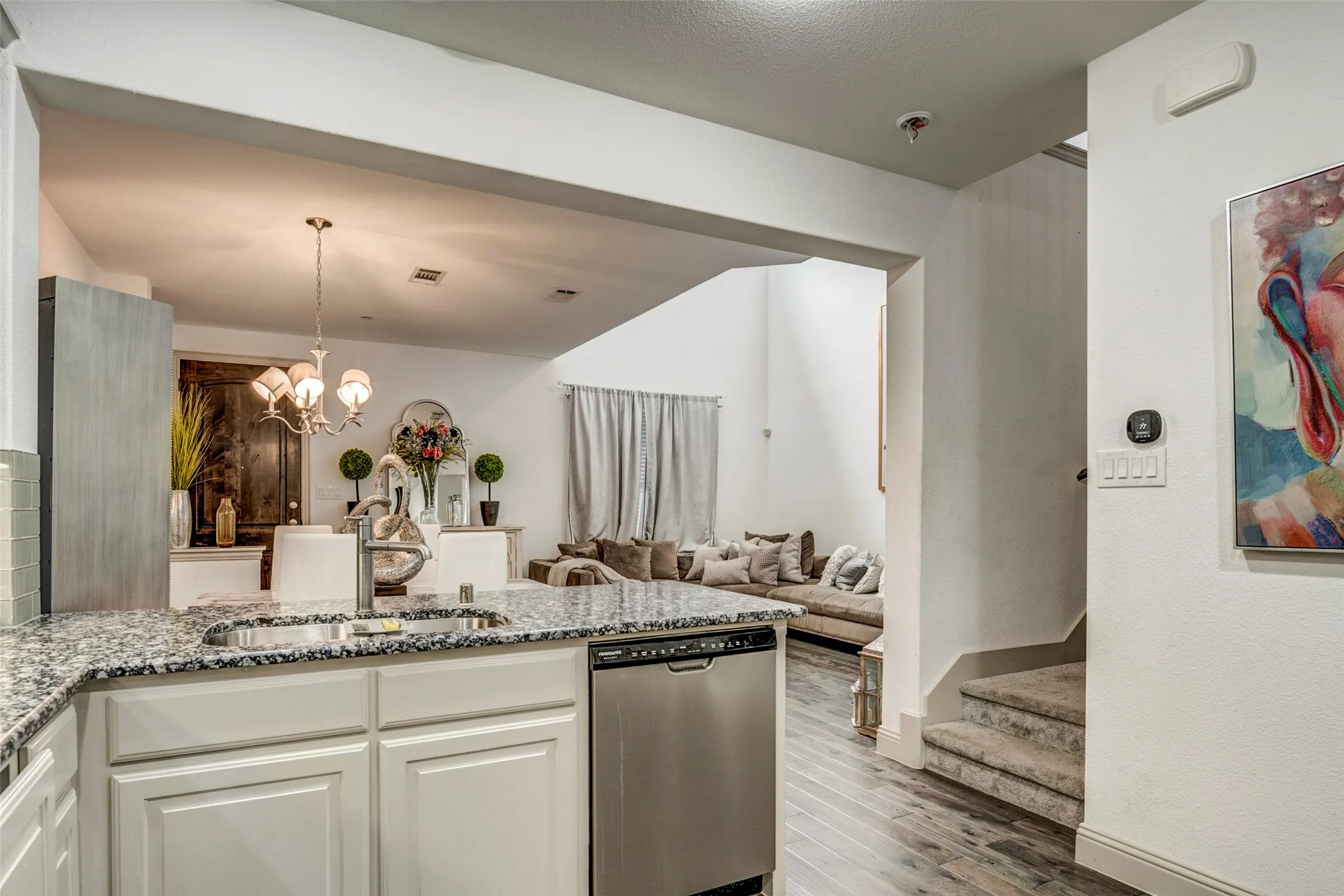 Kitchen island with granite-finish countertop, undermount stainless steel sink, and stainless steel dishwasher