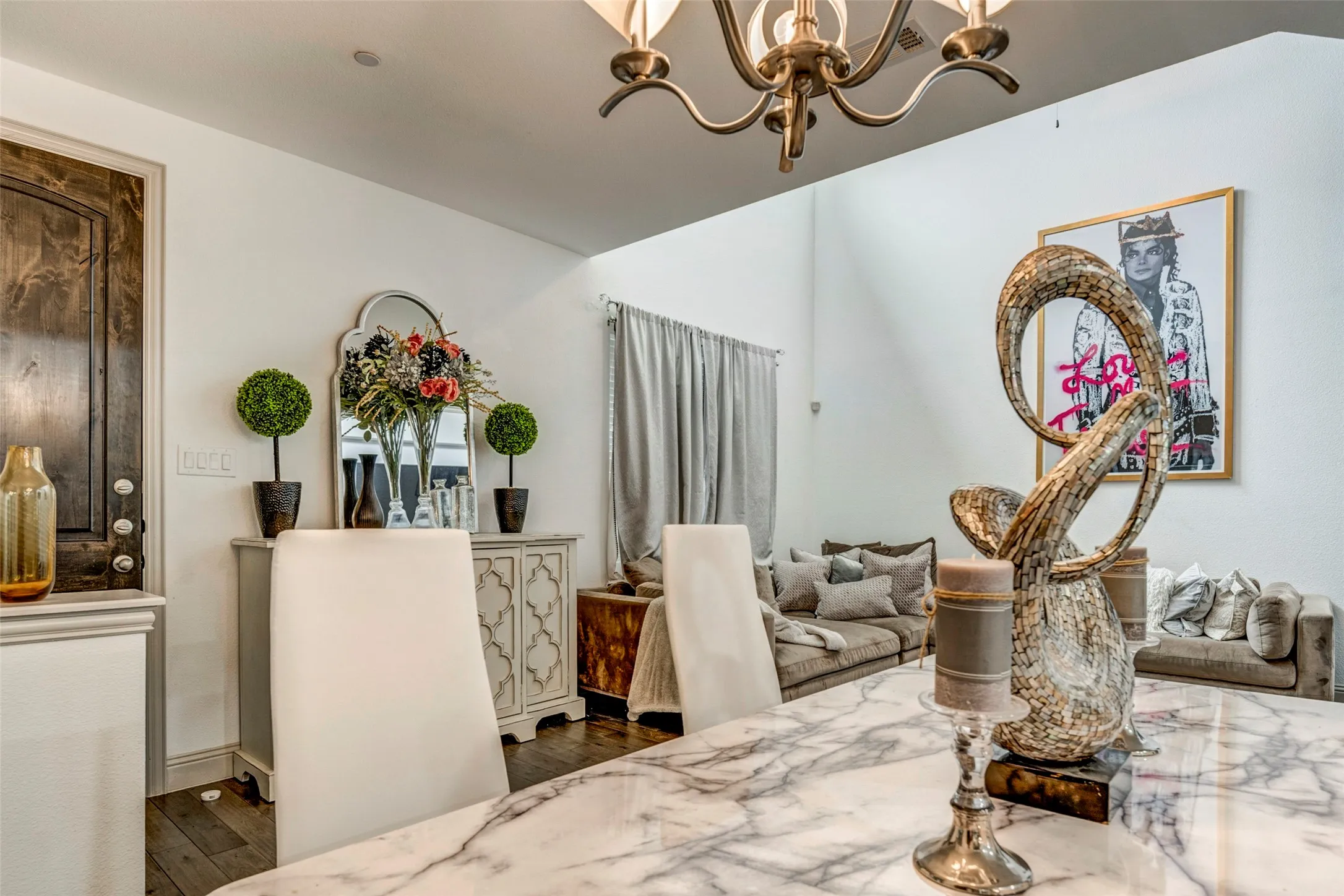 Dining area featuring a marble-finish table, a decorative chandelier, and wood-finish flooring