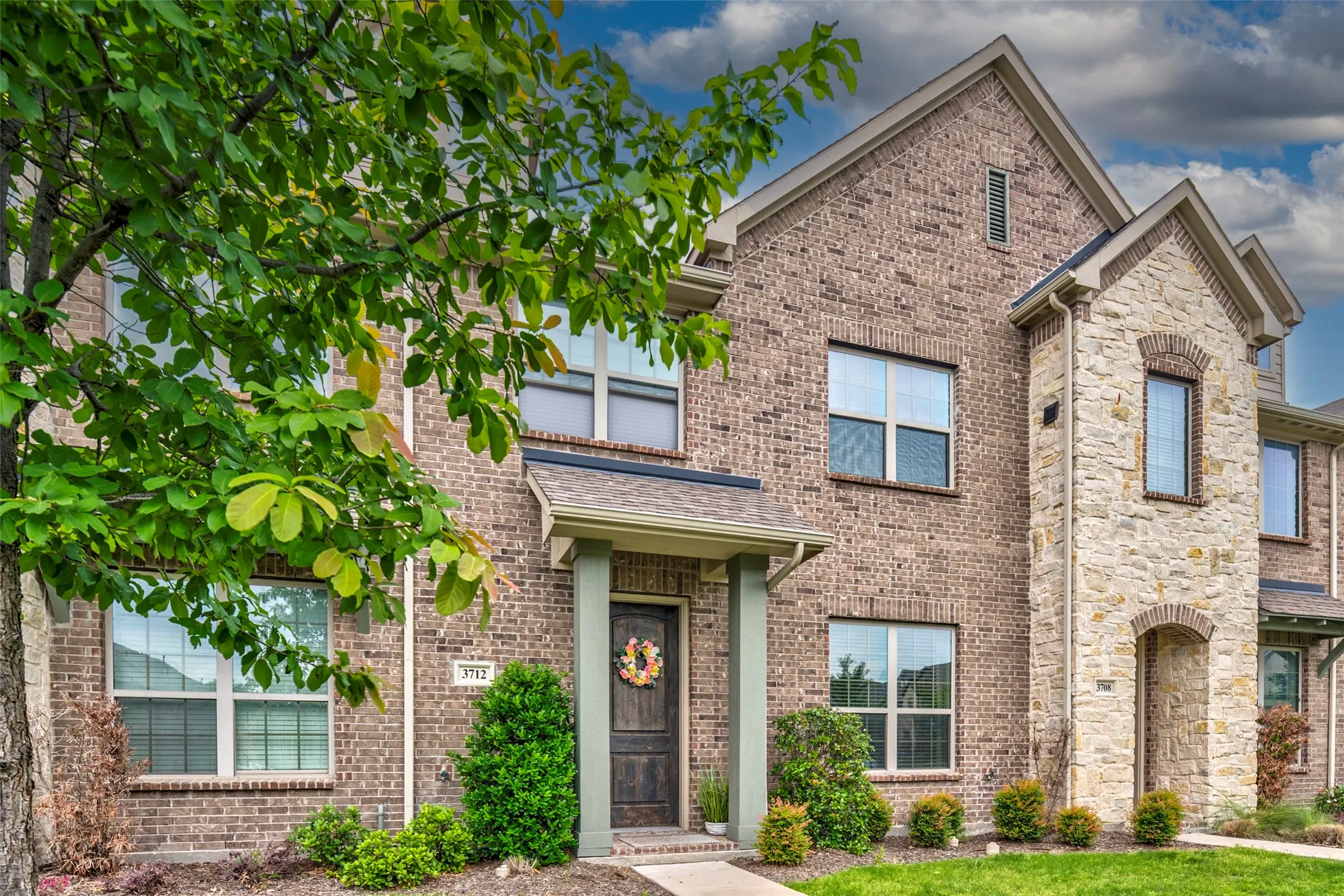 Exterior facade featuring a combination of brick and natural stone accents