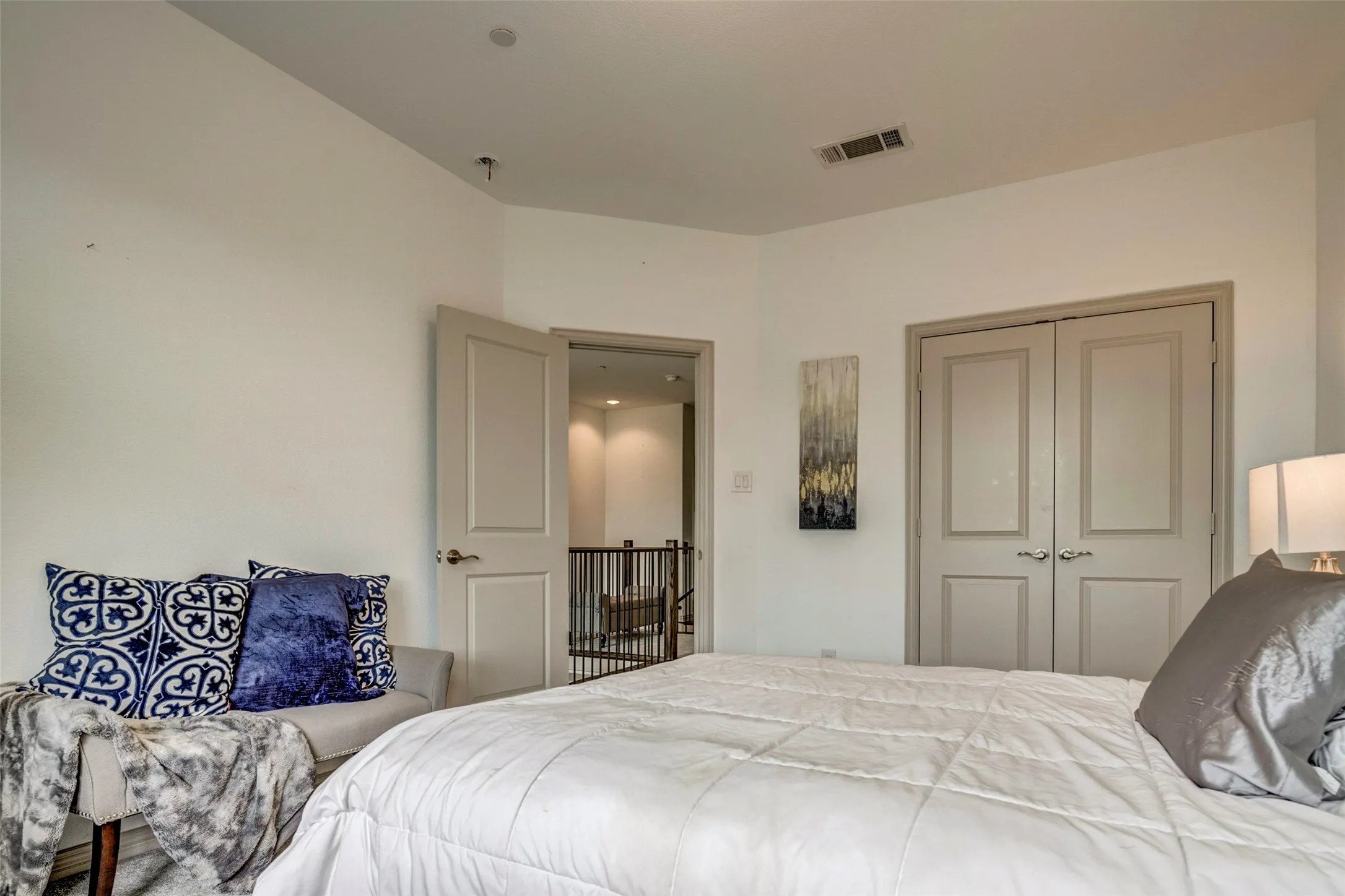 Spacious room featuring light neutral wall tones, a double-door closet, and an interior doorway providing access to another area of the property